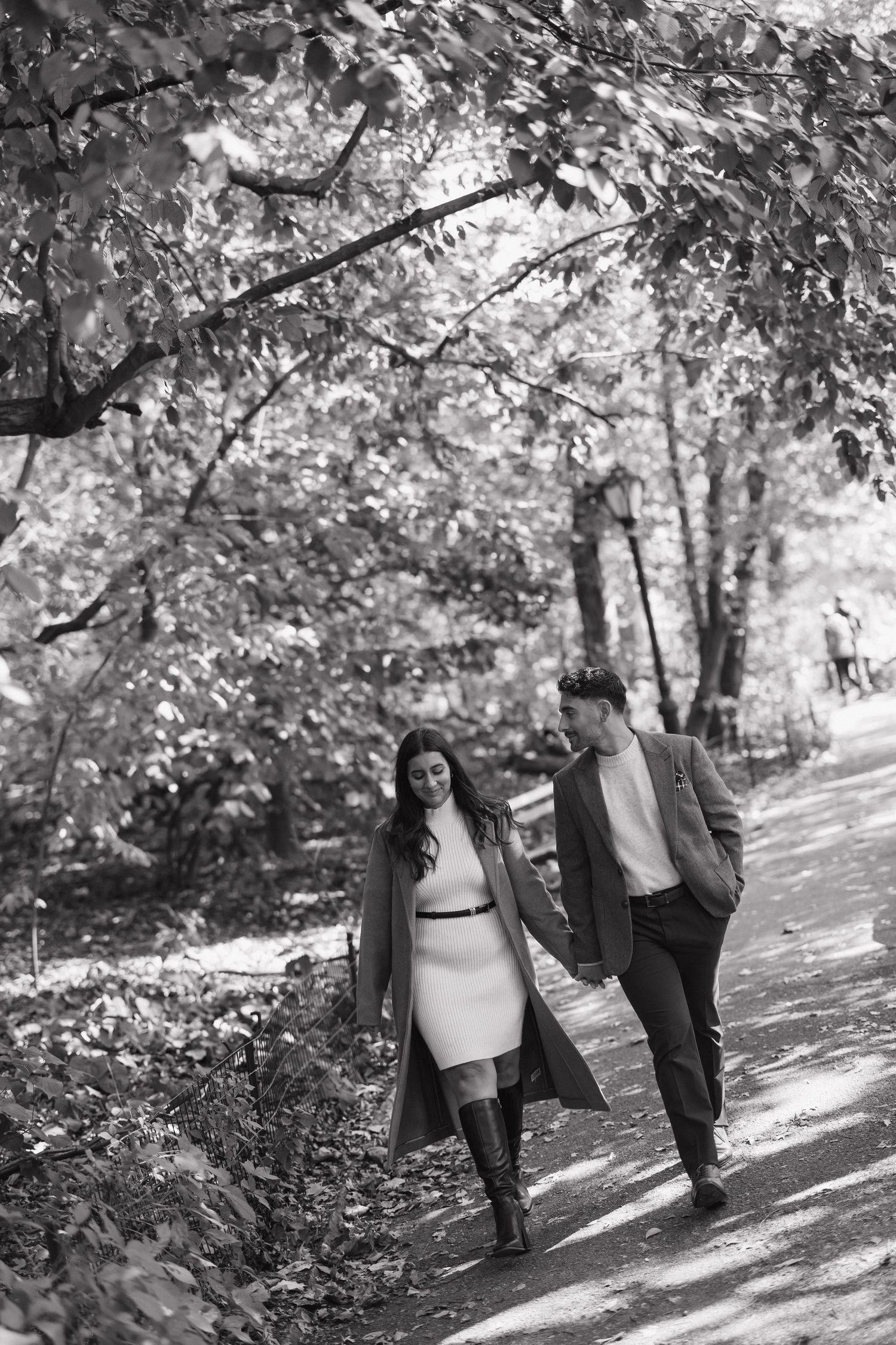 A series of black and white photos showing a couple walking together on a tree-lined path.