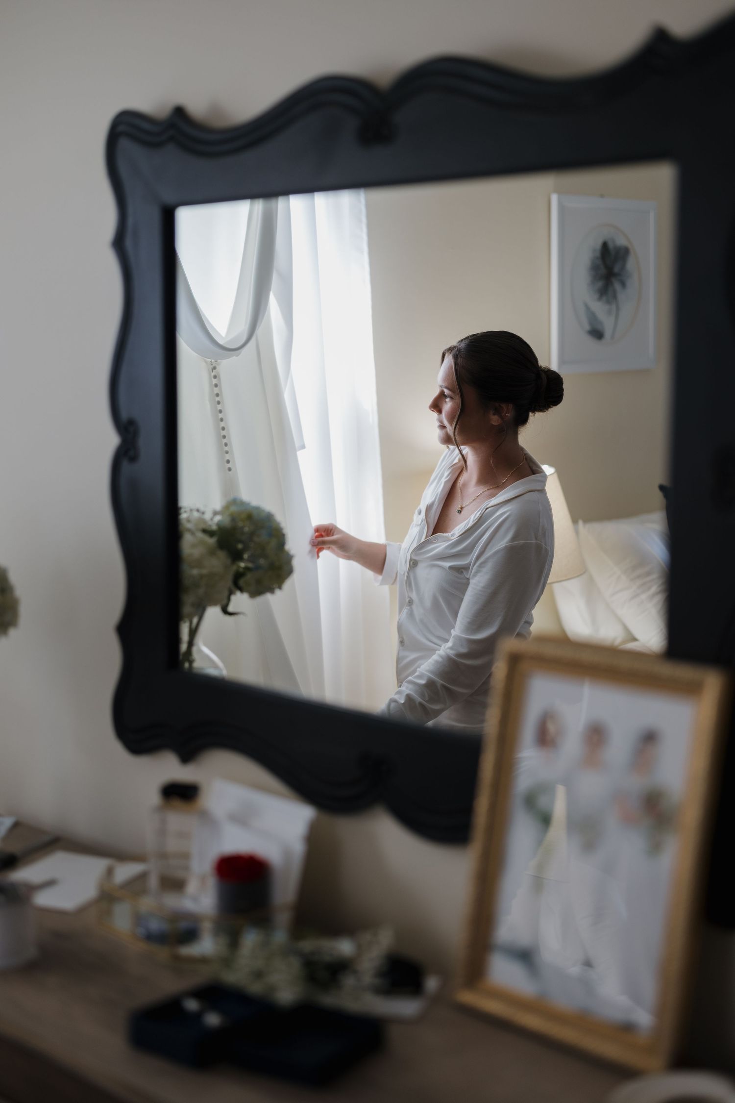 A series of getting ready photos showing a bridal preparation scene reflected in an ornate black-framed mirror.