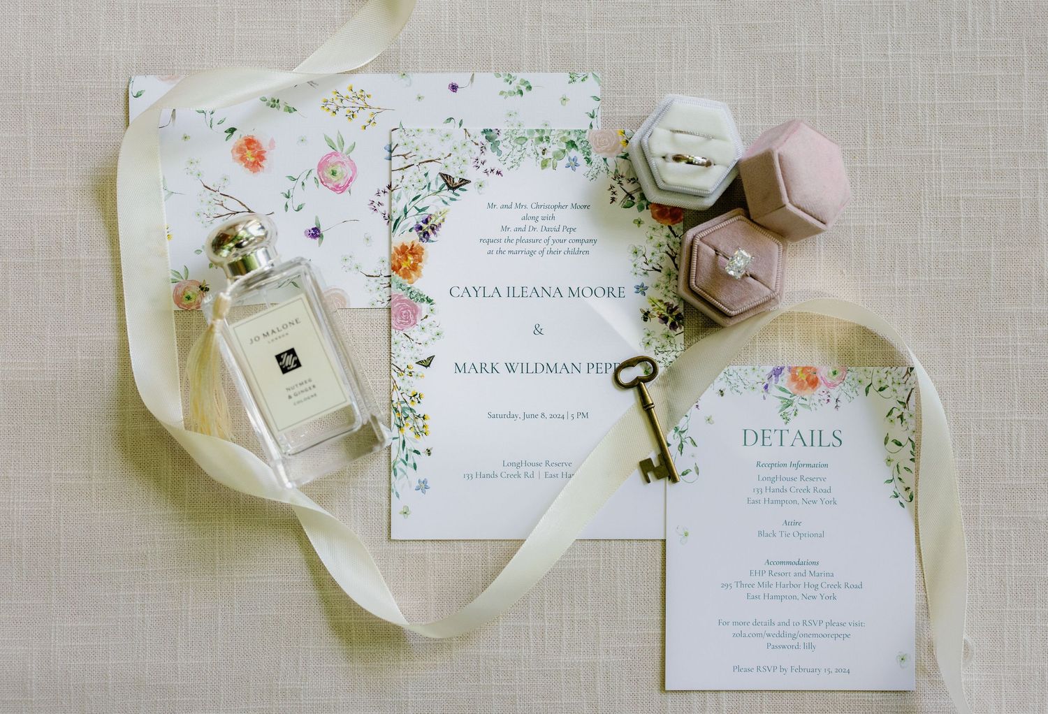 Elegant wedding invitation suite with floral designs and delicate details displayed on light linen background.