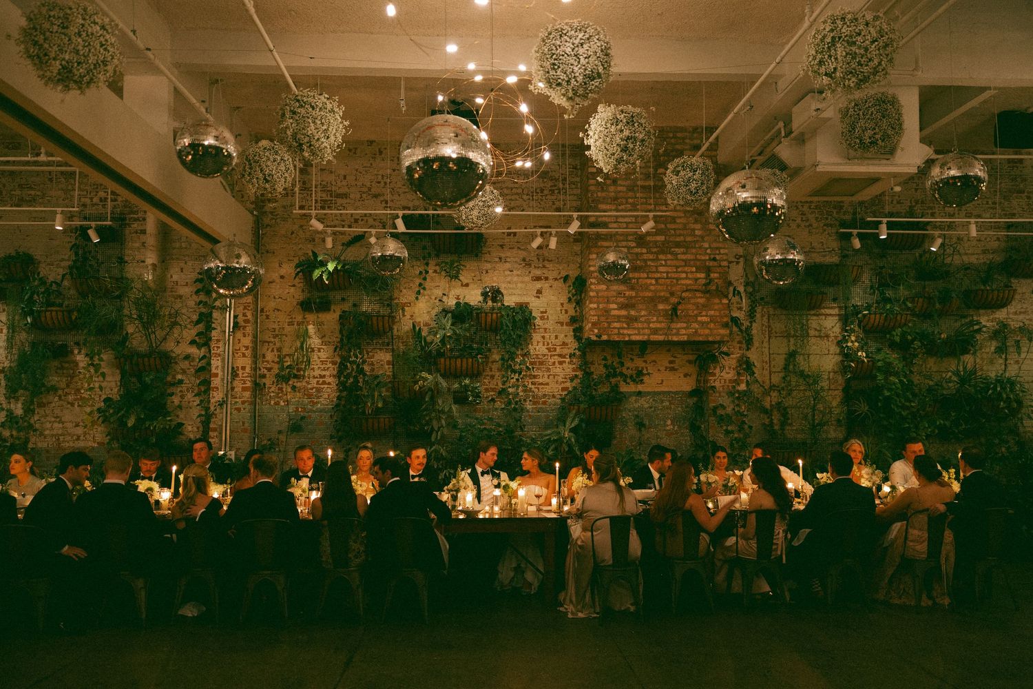 Wedding reception venue decorated with string lights and greenery creating a warm, romantic atmosphere.