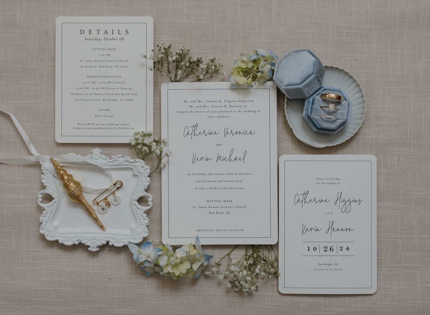 Elegant wedding stationery suite featuring white invitations, blue accents, and delicate floral details on a neutral linen background.