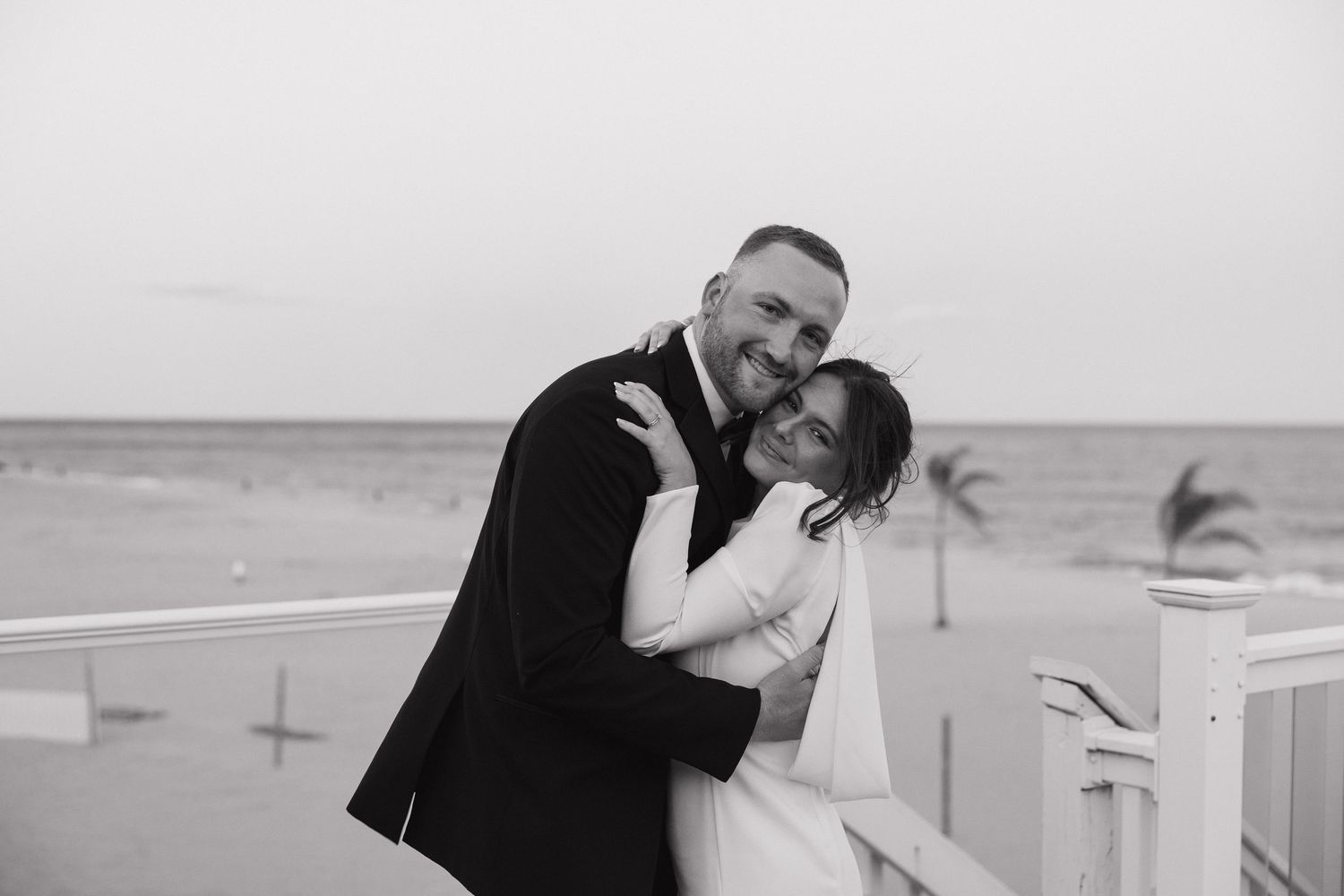 A black and white collage of romantic wedding photos showing couples embracing on a beach.