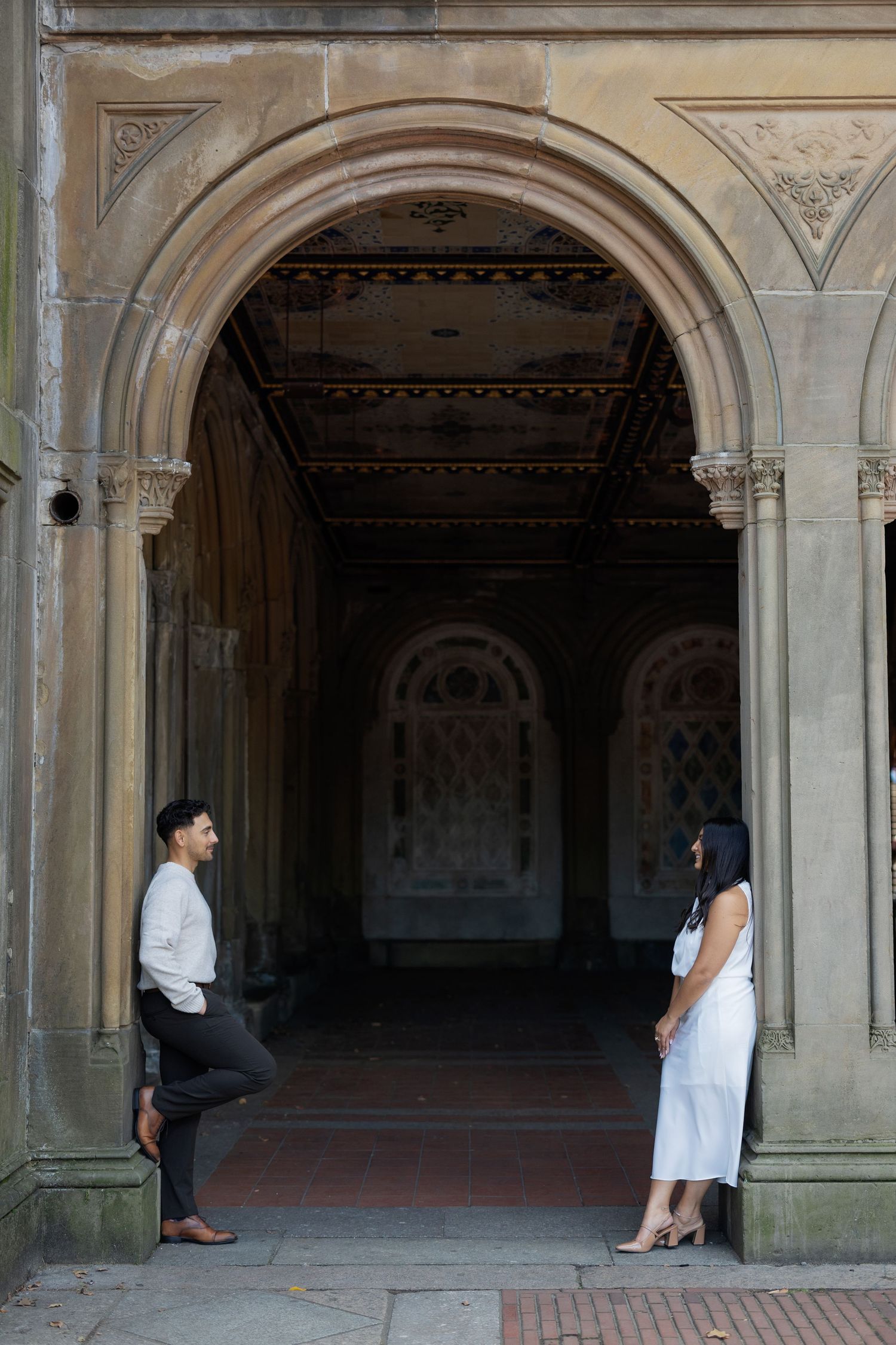 A sequence of photos showing a couple in an ornate stone archway corridor.