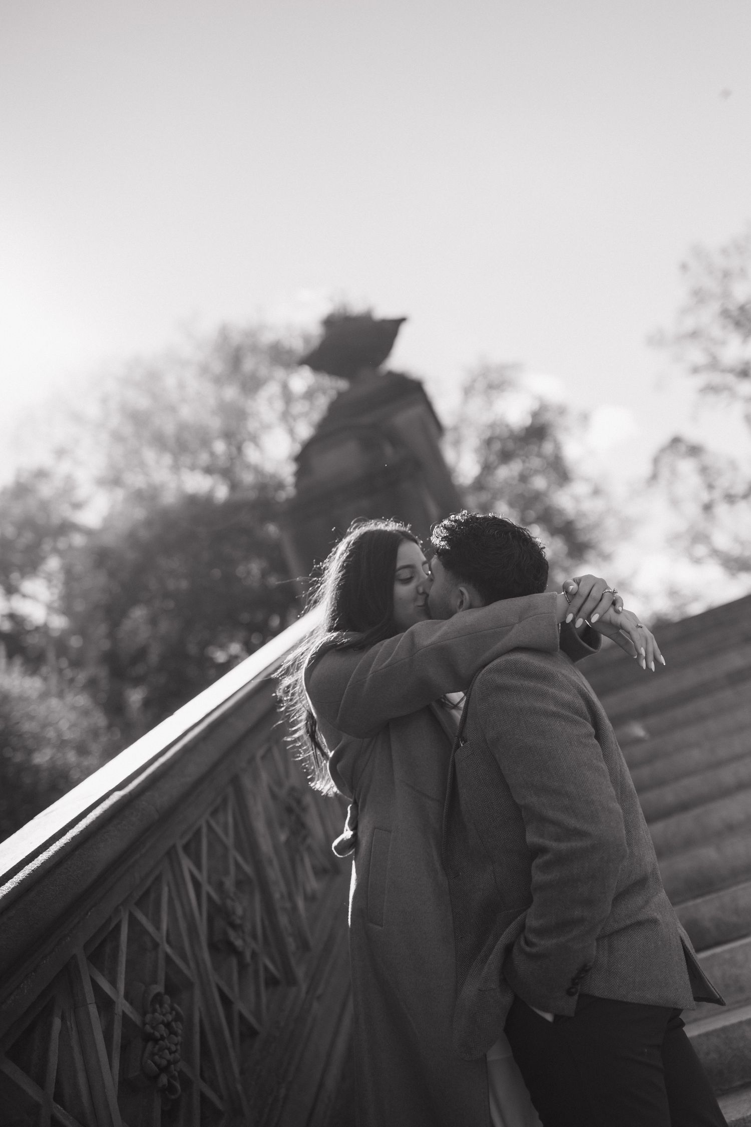 Silhouetted couple embracing on steps during a romantic sunset moment.
