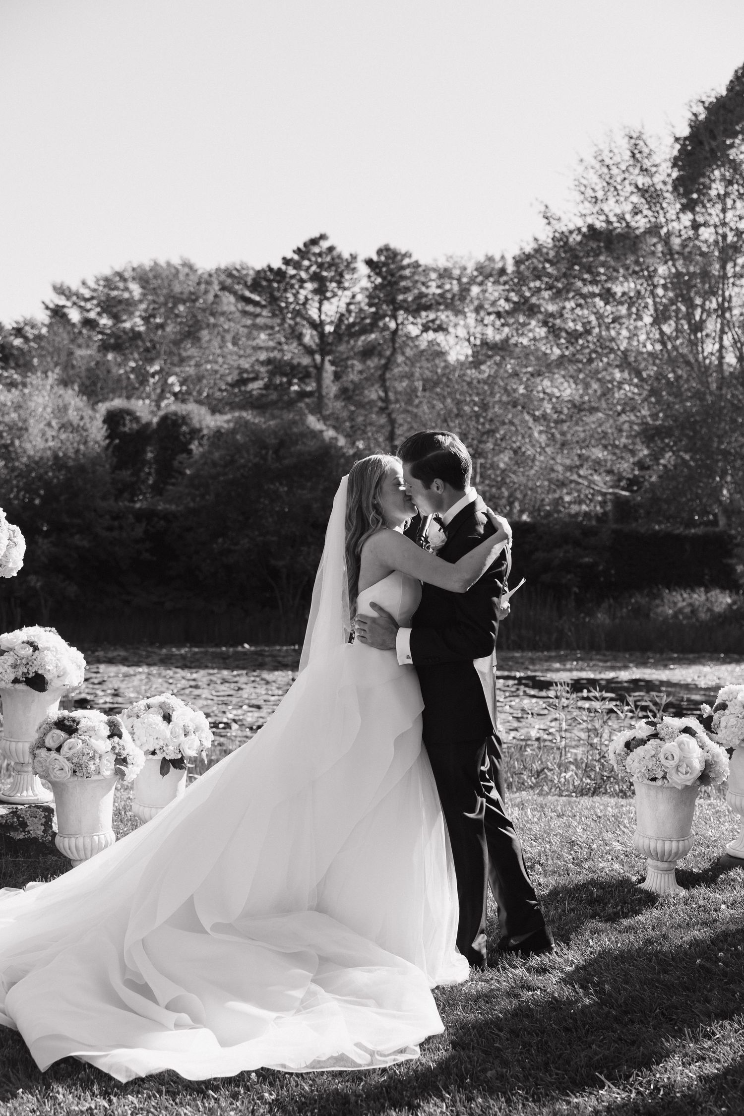 Black and white wedding photography sequence showing a romantic dance in an outdoor garden setting.