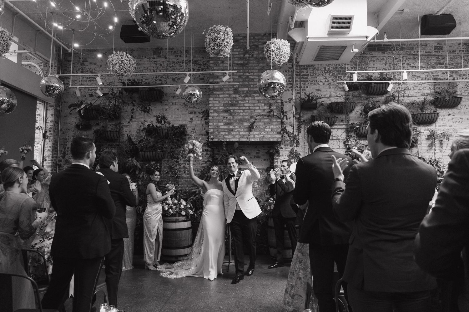 A crowd of people dancing under a disco ball at a party or nightclub celebration.