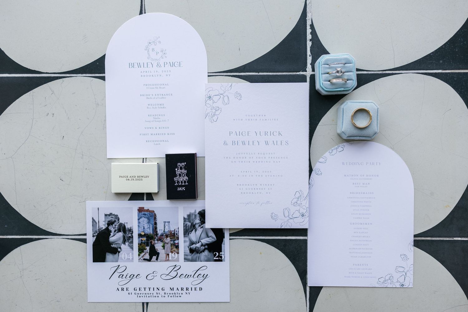 Elegant wedding stationery and invitations displayed in a row against a geometric patterned wall.