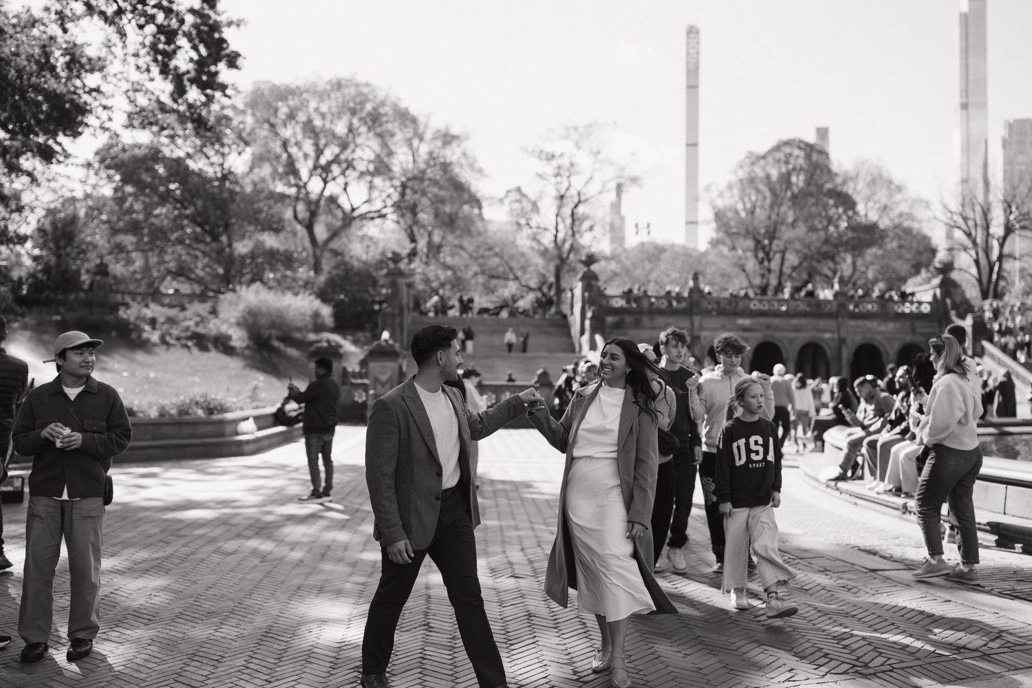 A series of candid photos showing a couple's special moment against an urban park backdrop.