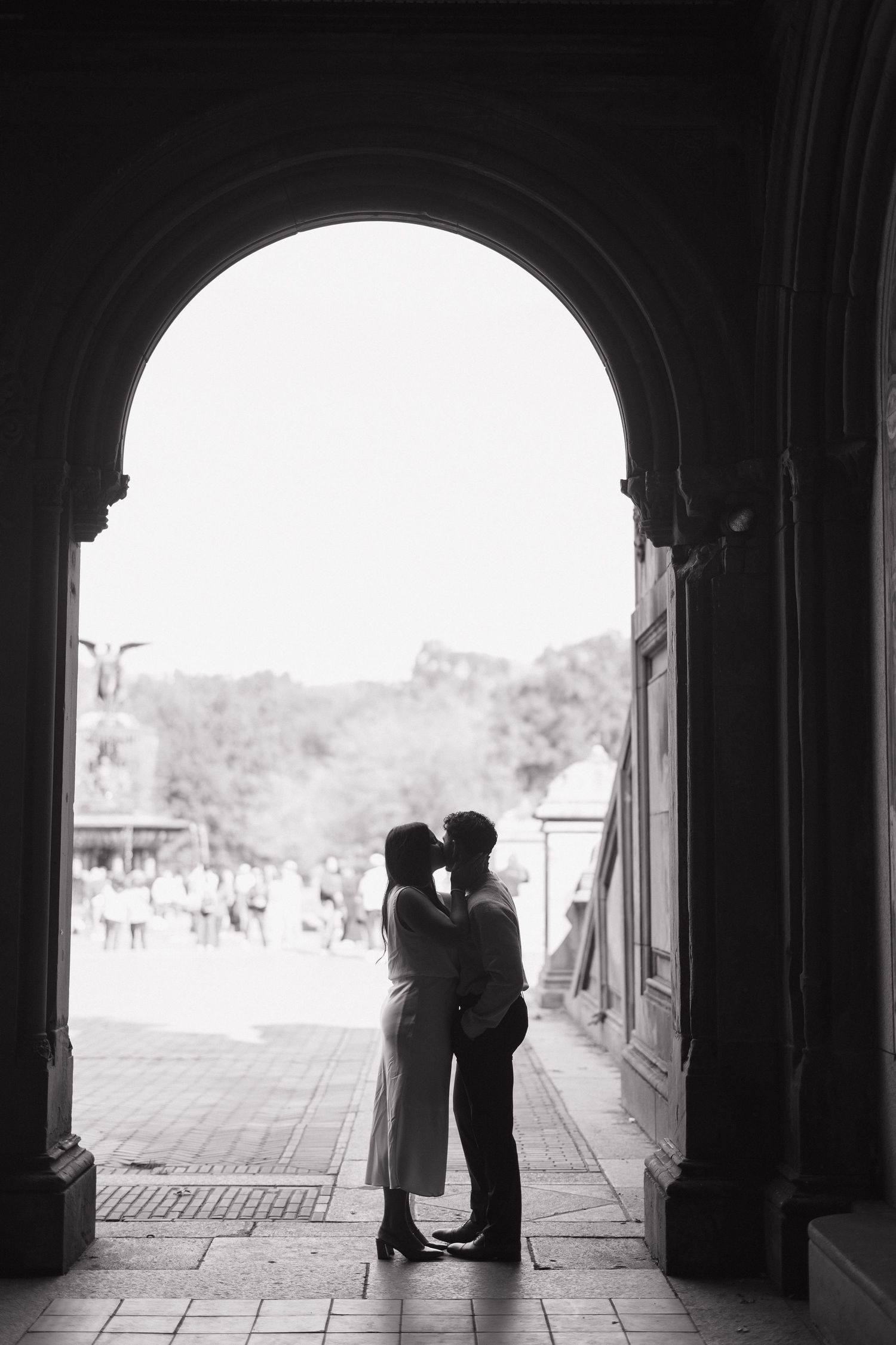 Black and white photo series showing silhouettes of people embracing under arched walkways.