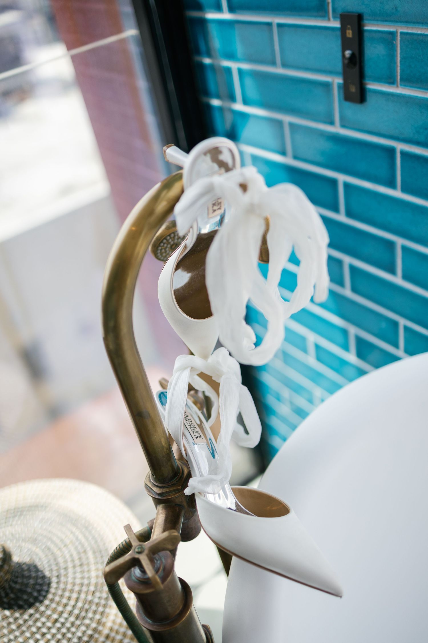 White ceramic decorative items arranged against a turquoise tiled wall in an artistic display.