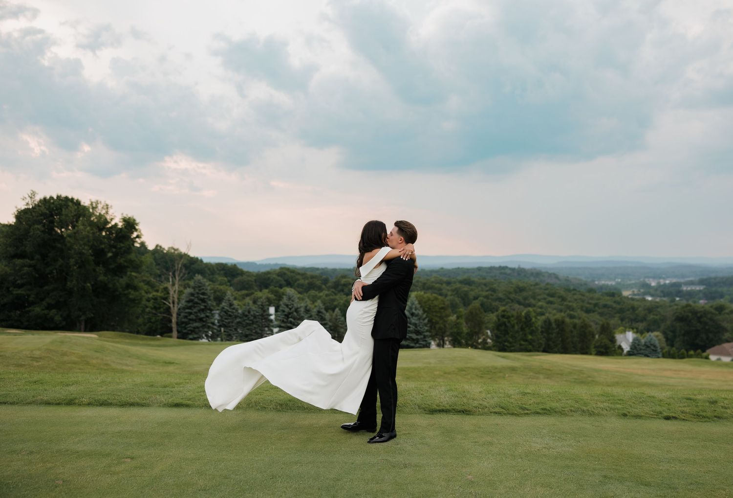 Scenic outdoor wedding photography session in rolling hills during golden hour.