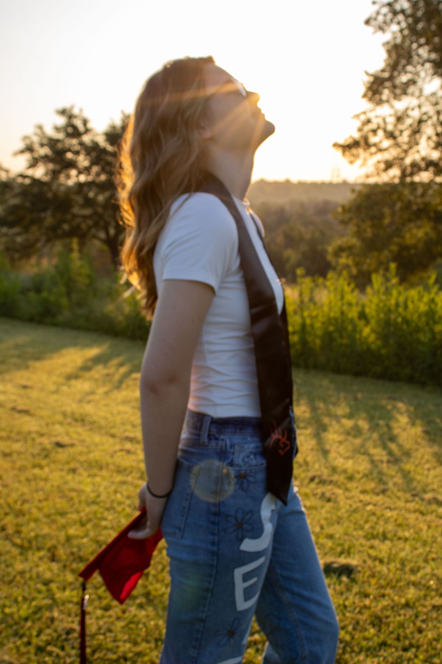grad posing in front of sunrise