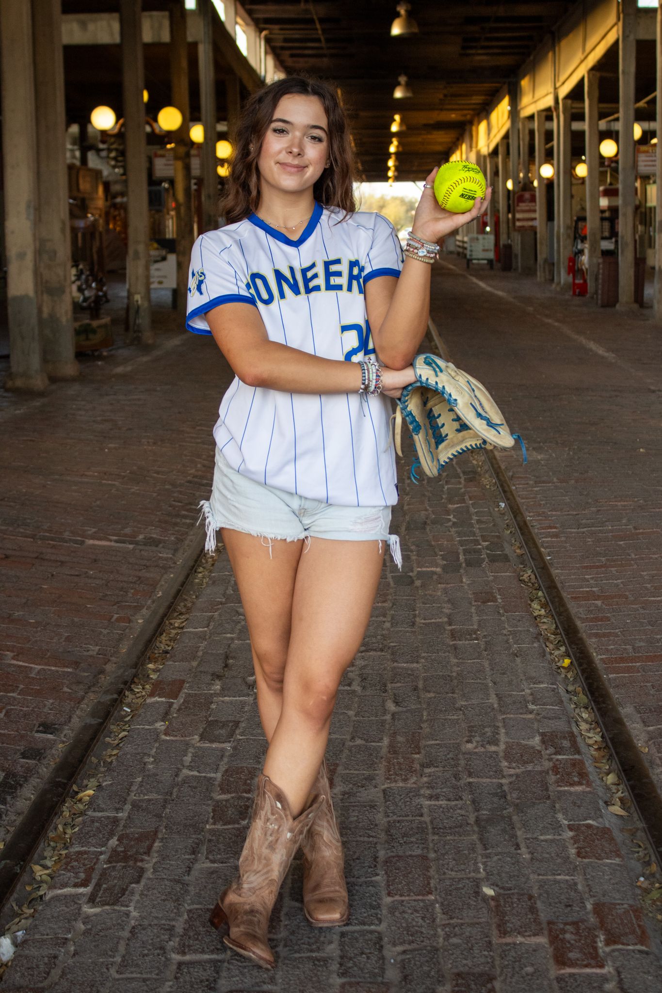 girl posing in Softball uniform in FW Stockyards