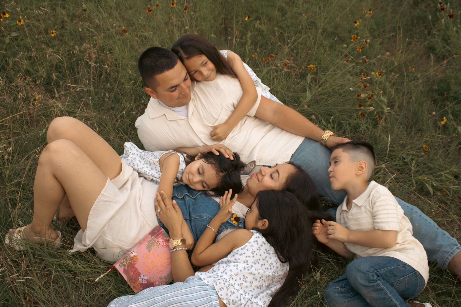 family lying in grass