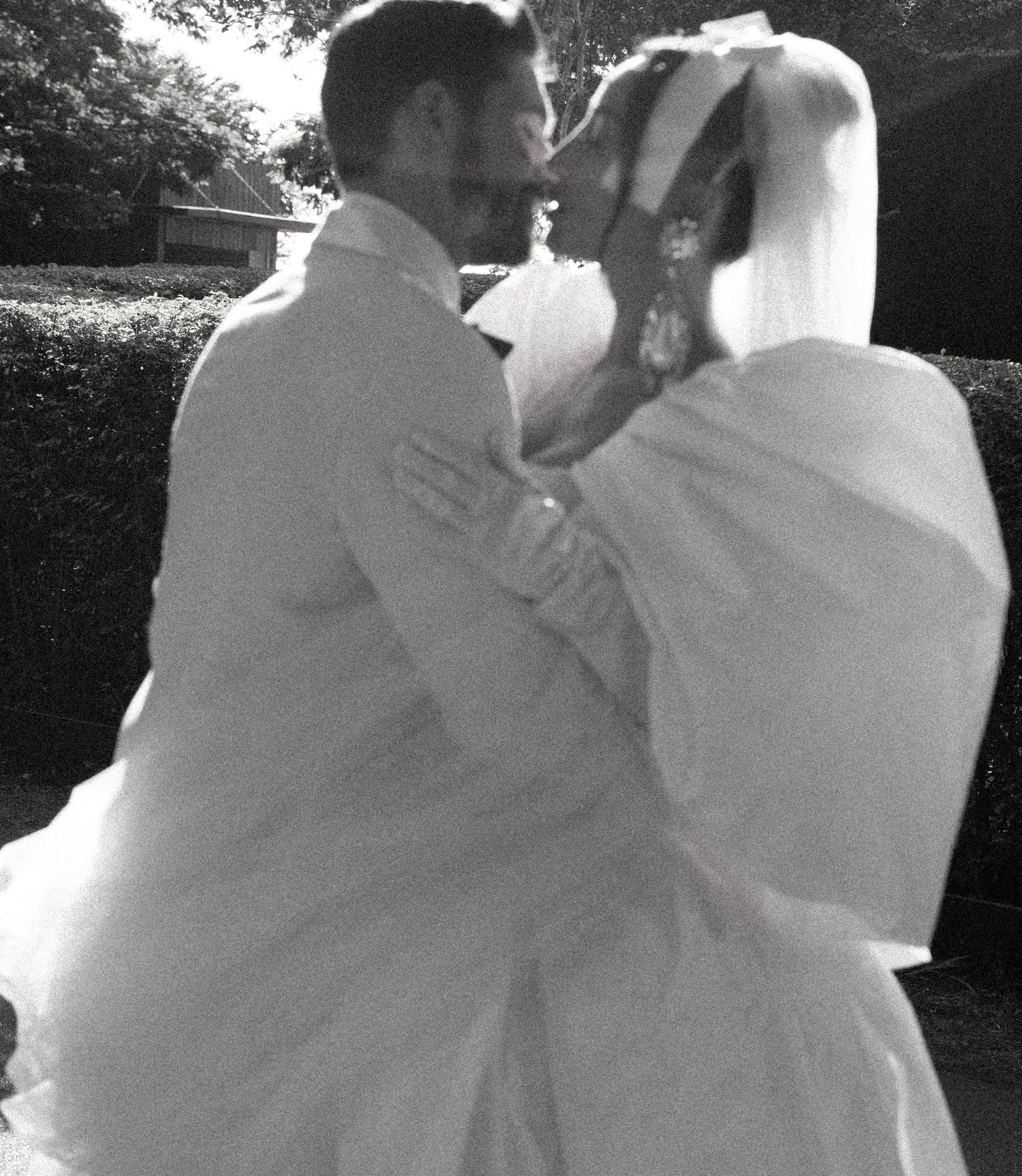 Intimate black and white wedding portrait capturing a romantic moment between newlyweds.