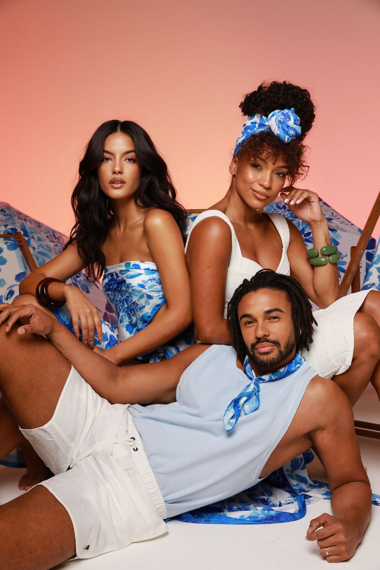 Models in blue and white outfits pose together holding colorful product packages.
