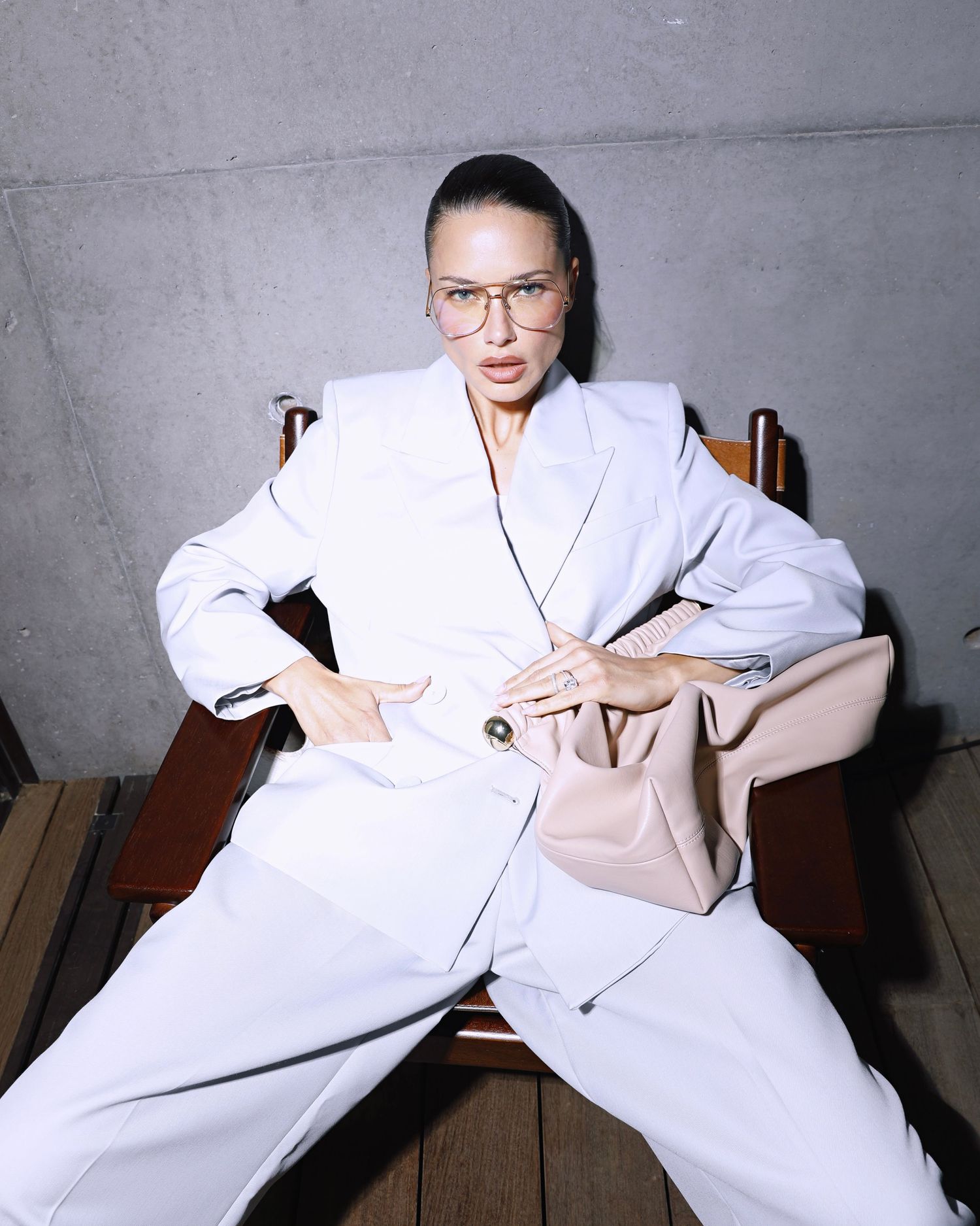 Series of artistic fashion photos showing person in white attire posing dramatically on furniture against gray background.