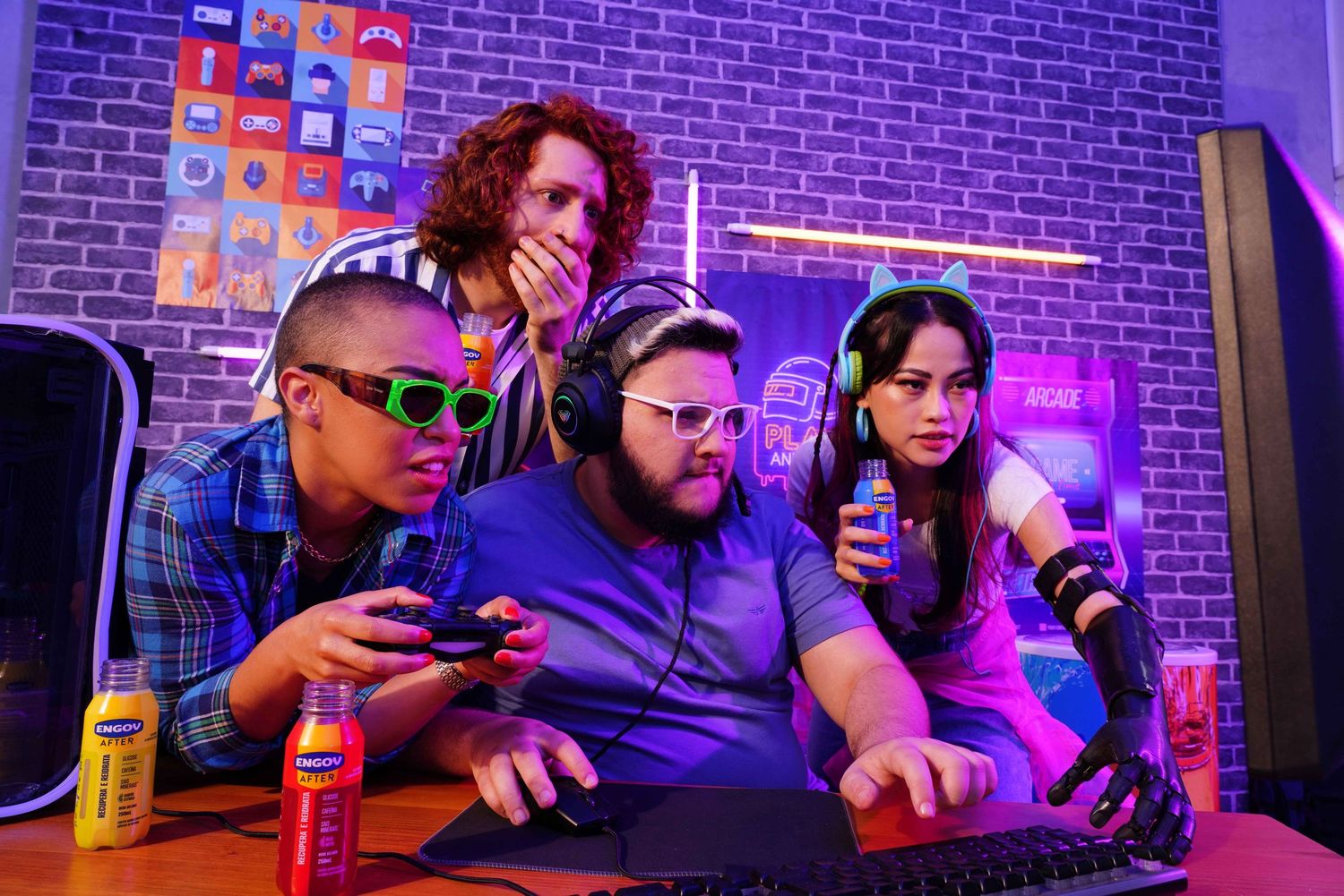 Friends playing video games together on a couch with neon lighting and brick wall background.