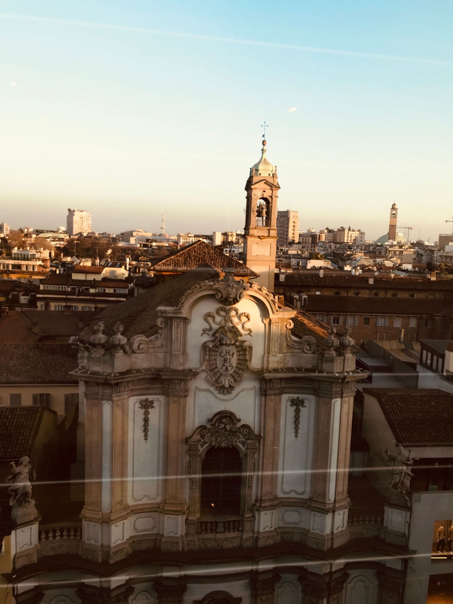 Historic baroque church facade with ornate details and bell tower overlooking the Porto cityscape at sunset.