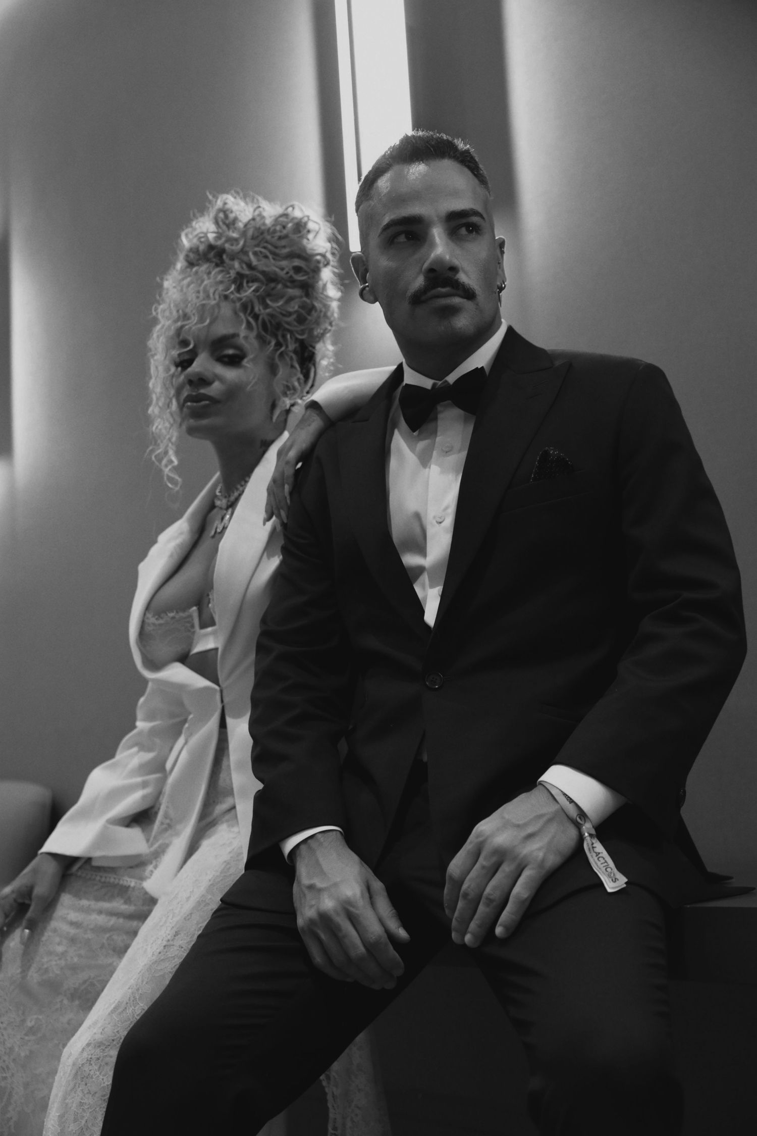 Black and white portrait of two people in formal attire posing together.