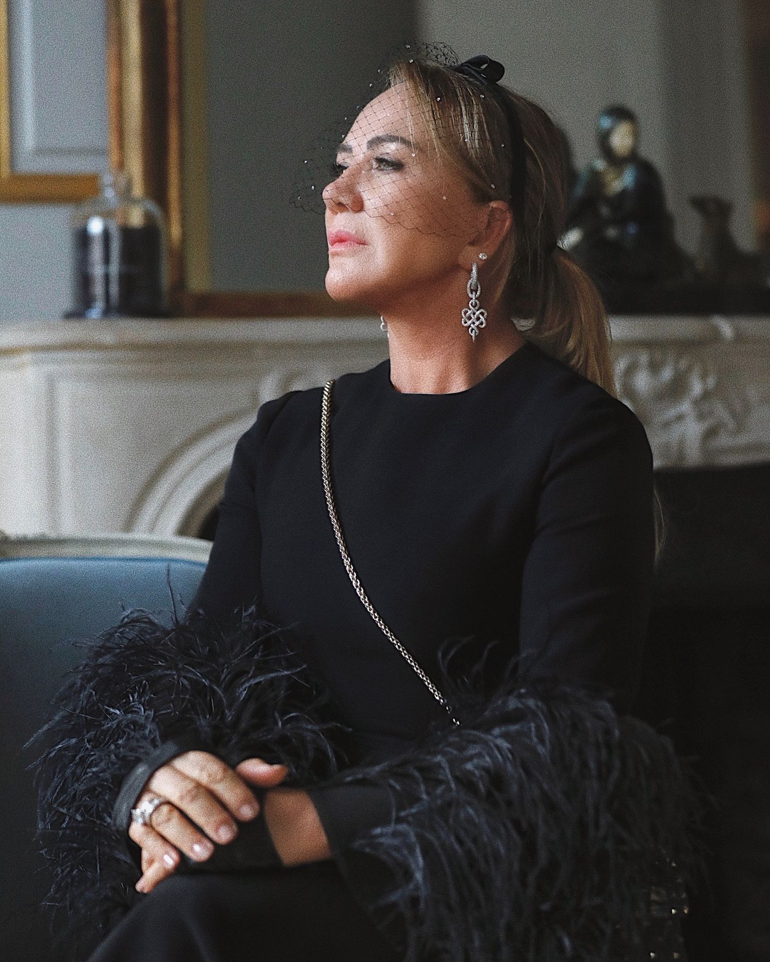 Portrait of someone in an elegant black feathered dress at a formal event.