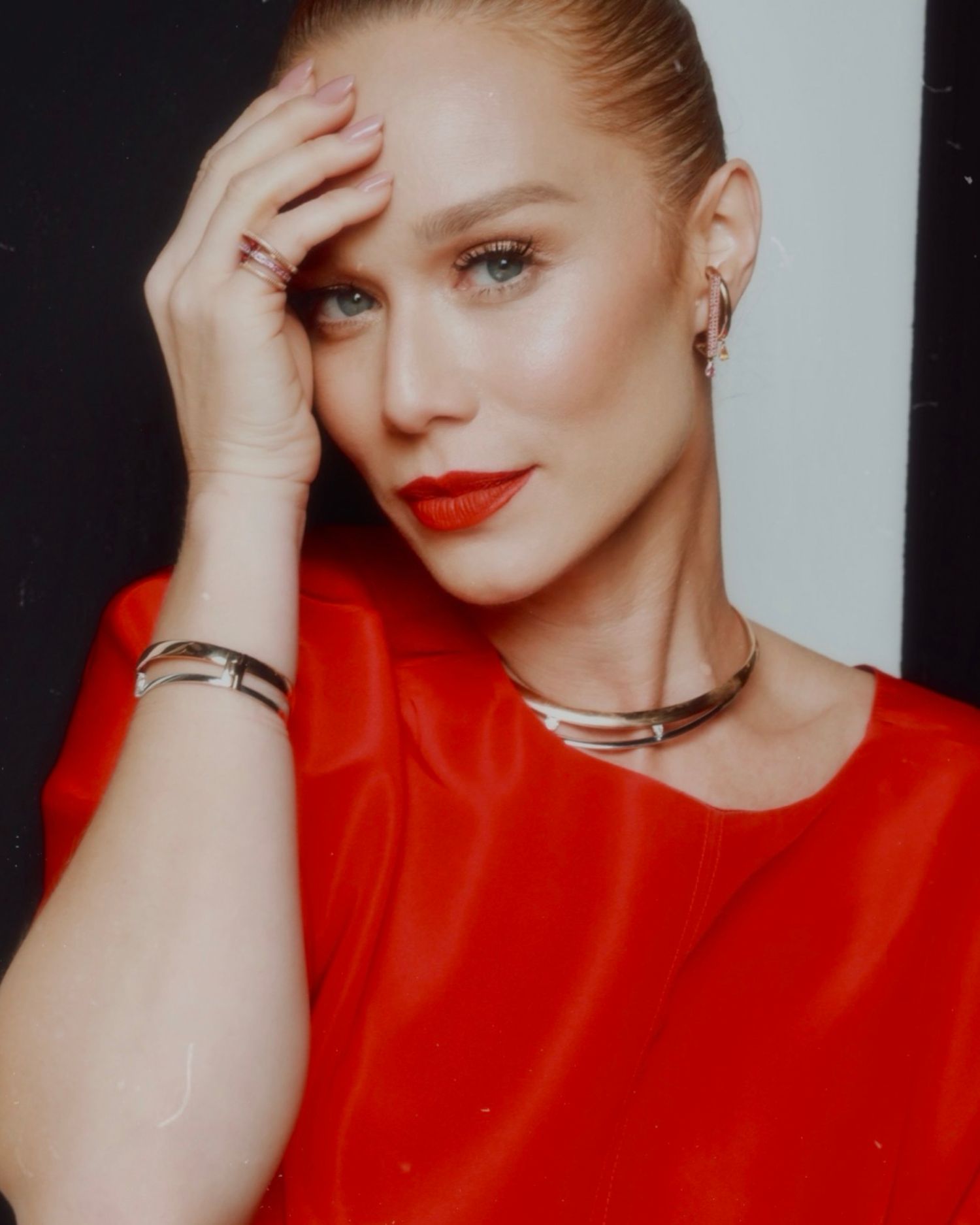 Fashion portrait of model in bright red top with bold lipstick and metallic necklace.