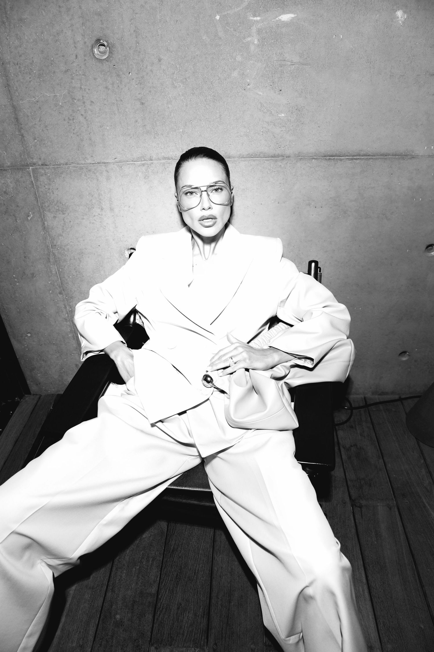 A series of black and white photos showing someone in white clothing sitting on a wooden floor in different poses.