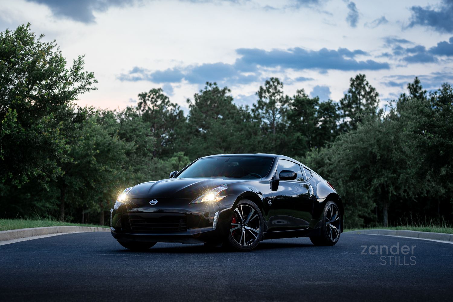 A stylistic image of a black Nissan 370Z parked in the middle of a roadway