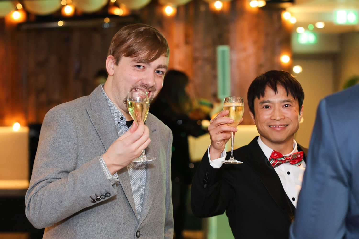 Xmas party drinks where two men are cheersing at the camera