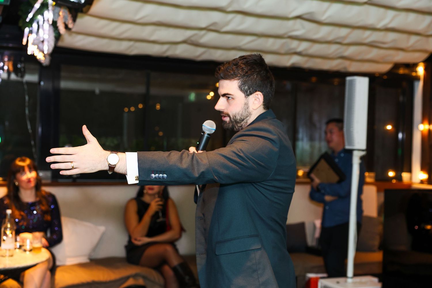 A host speaking and pointing tot he crowd at an event,