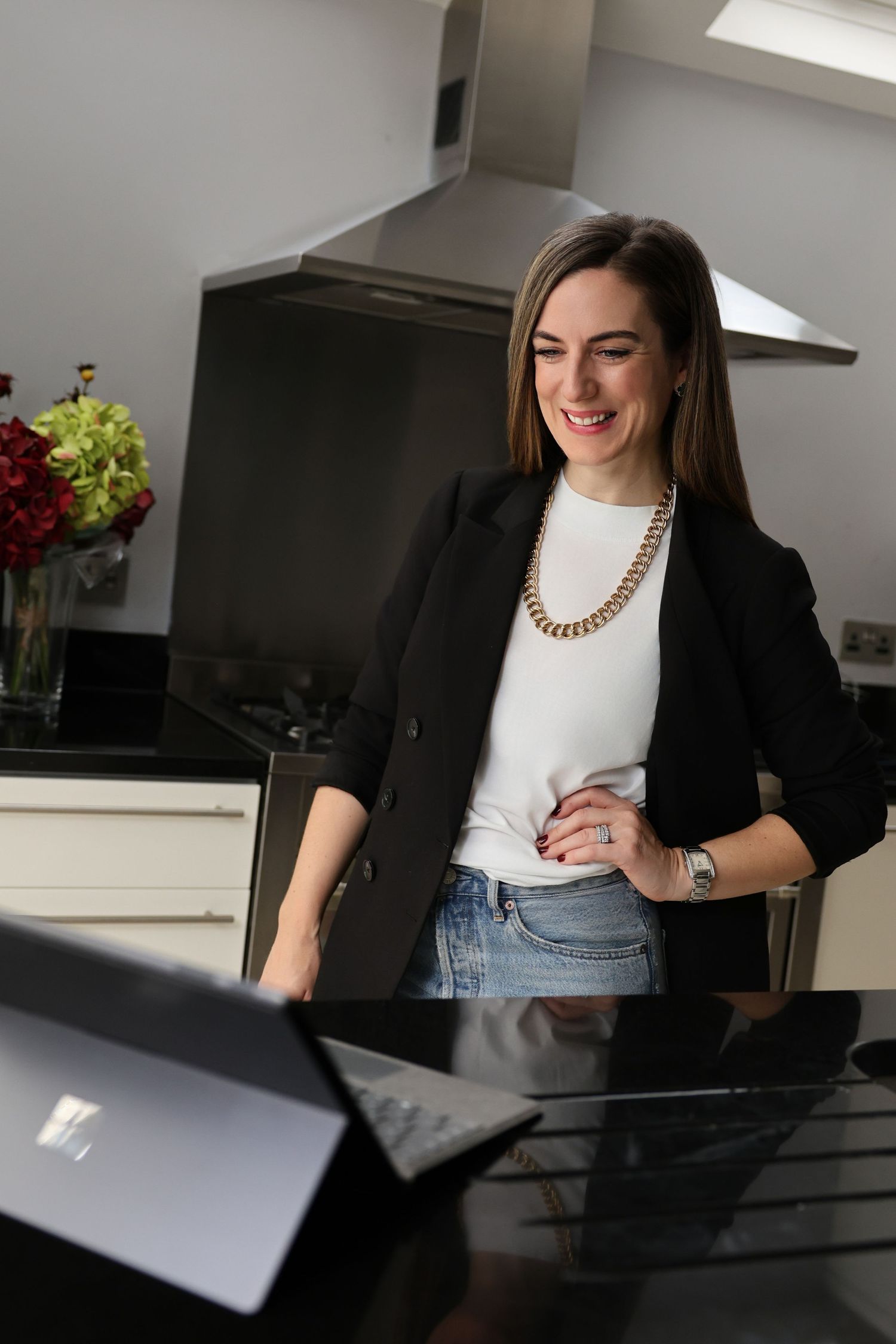 woman in her kitchen talking to her laptop
