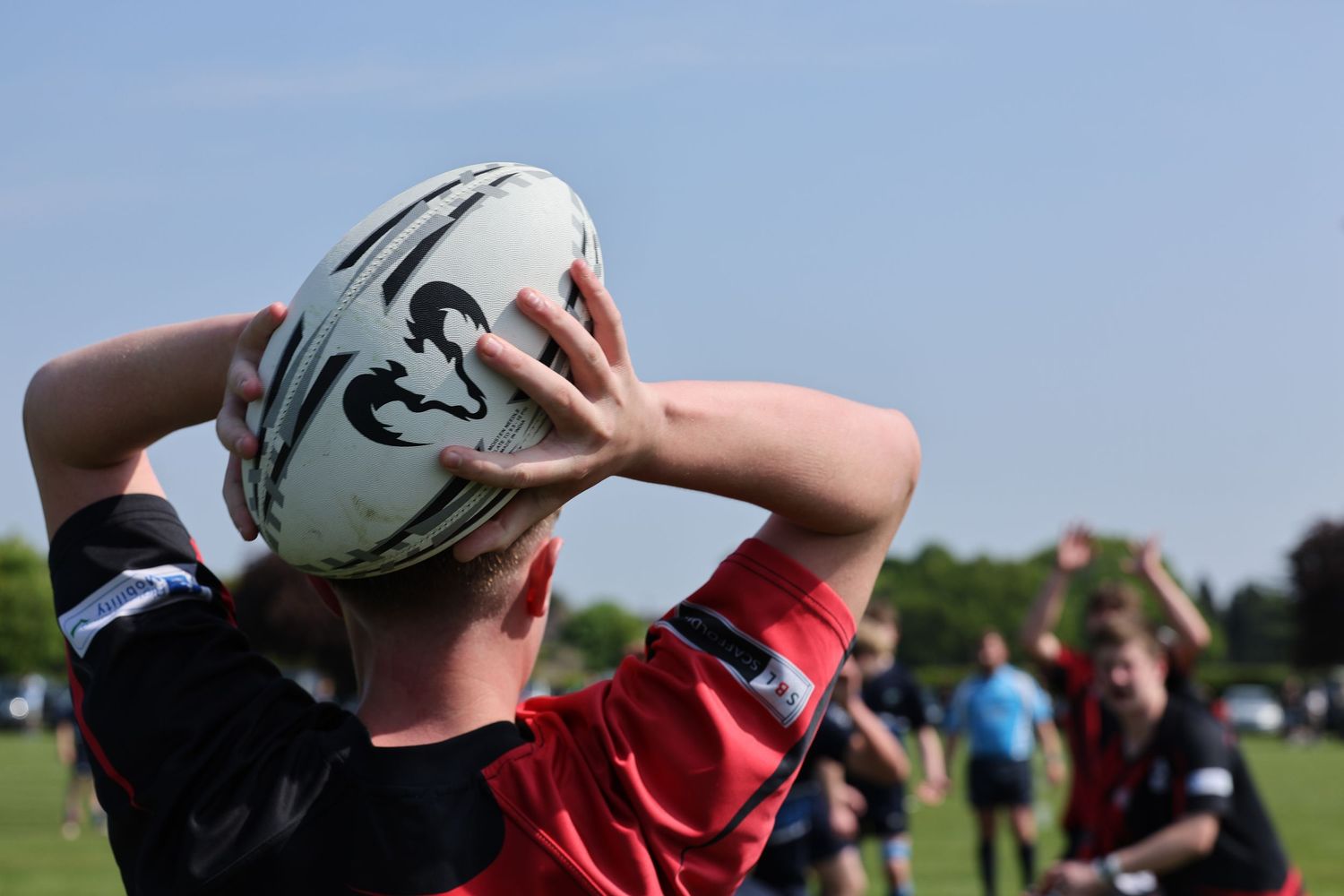 Rugby throw in from behind the thrower with a close up of the ball