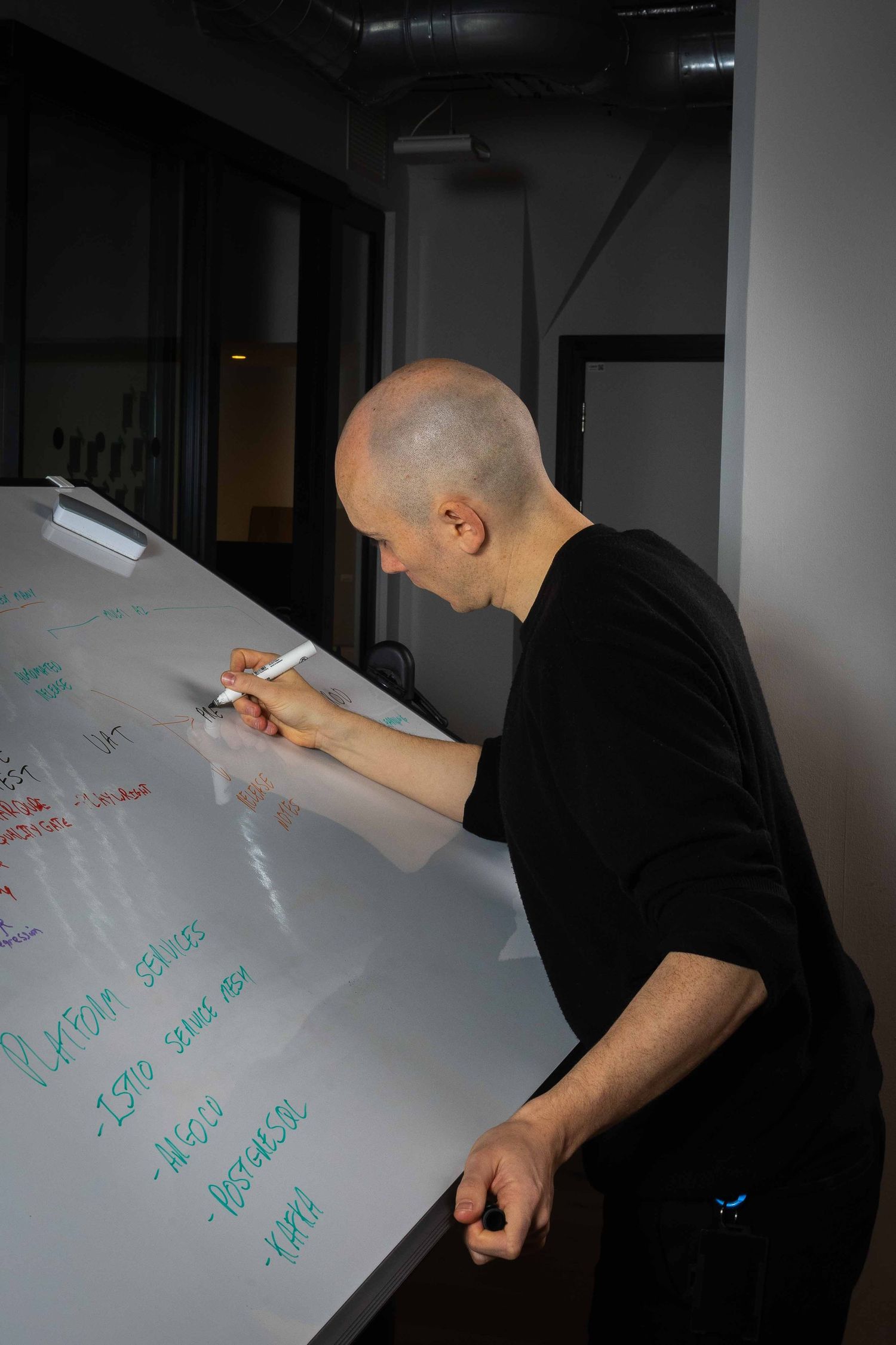 a bald man on a white board drawing