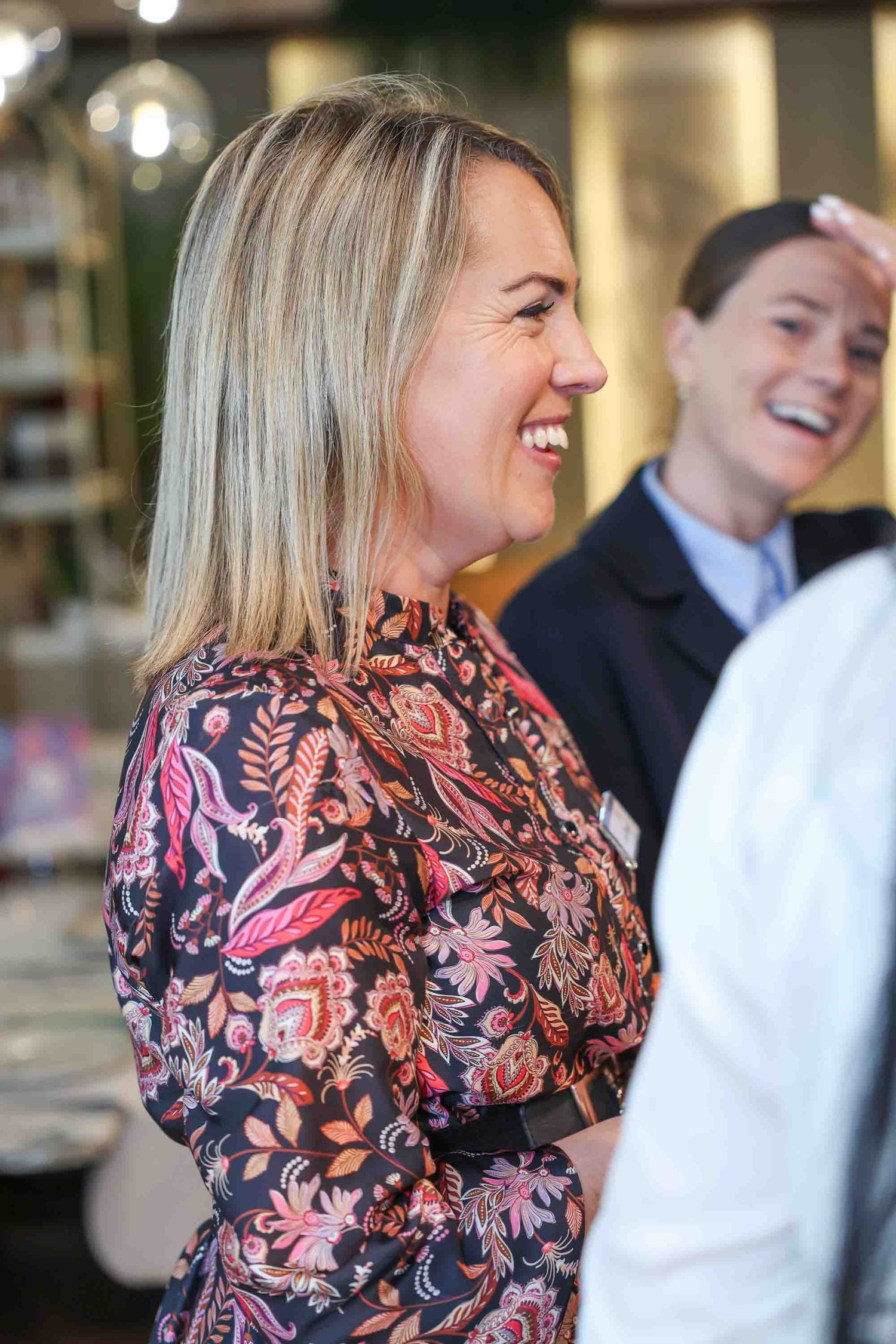 A blond lady smiling in the crowd at a network event