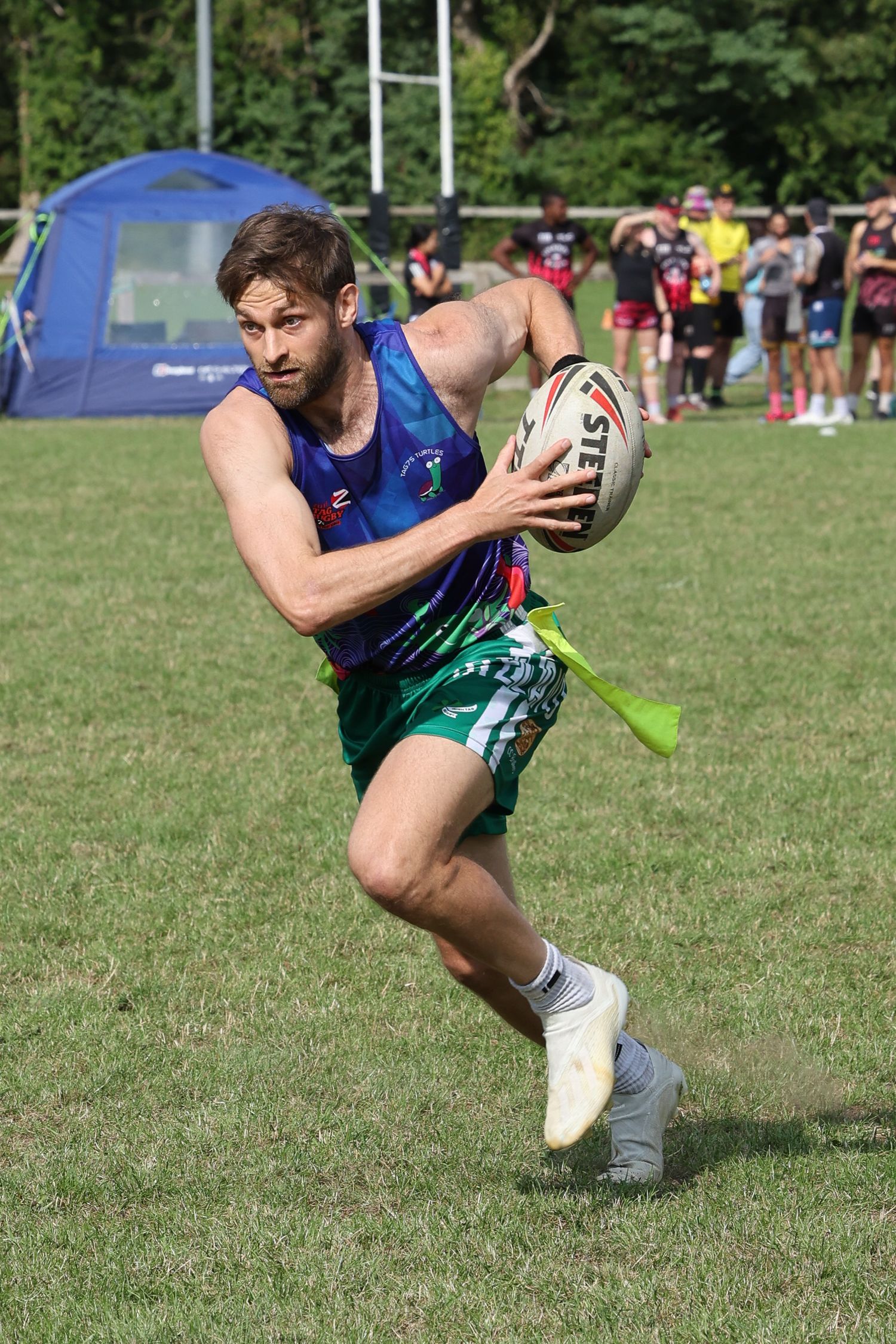 Man in full run with rugby ball and tags