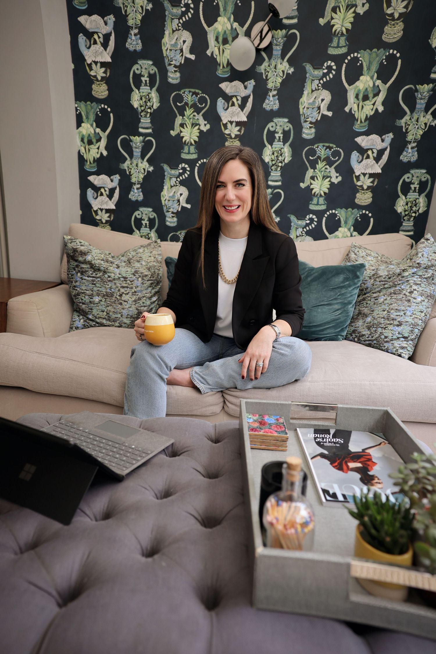 a woman casually sat on her sofa talking to her laptop