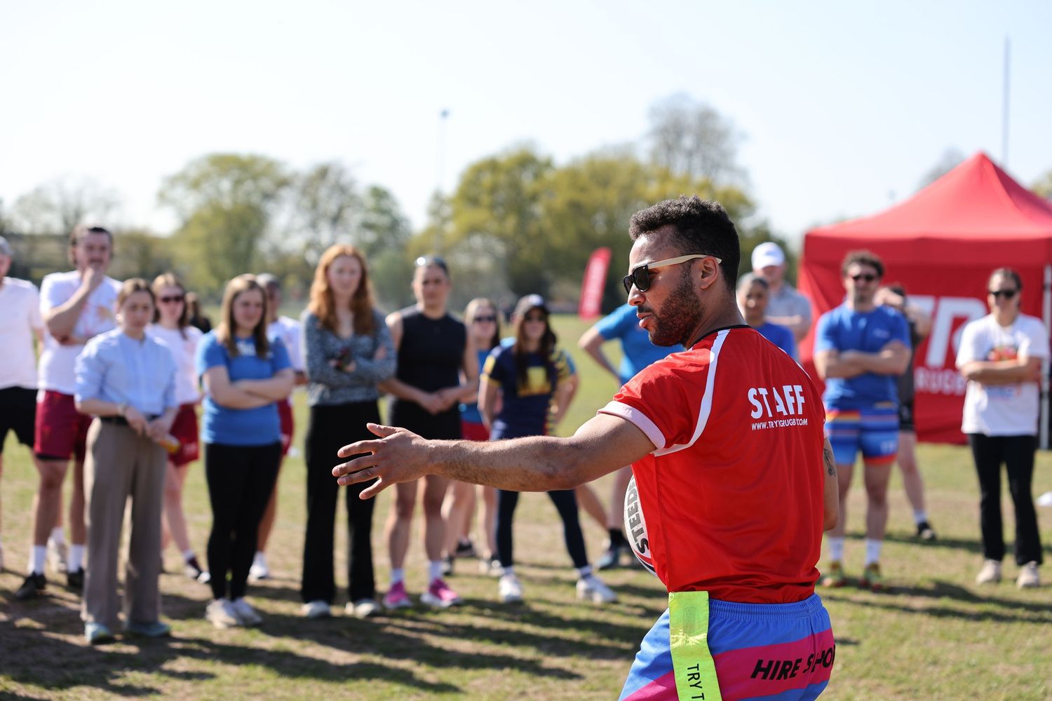 A man in a red shirt explaining the rule of the game to a group of players