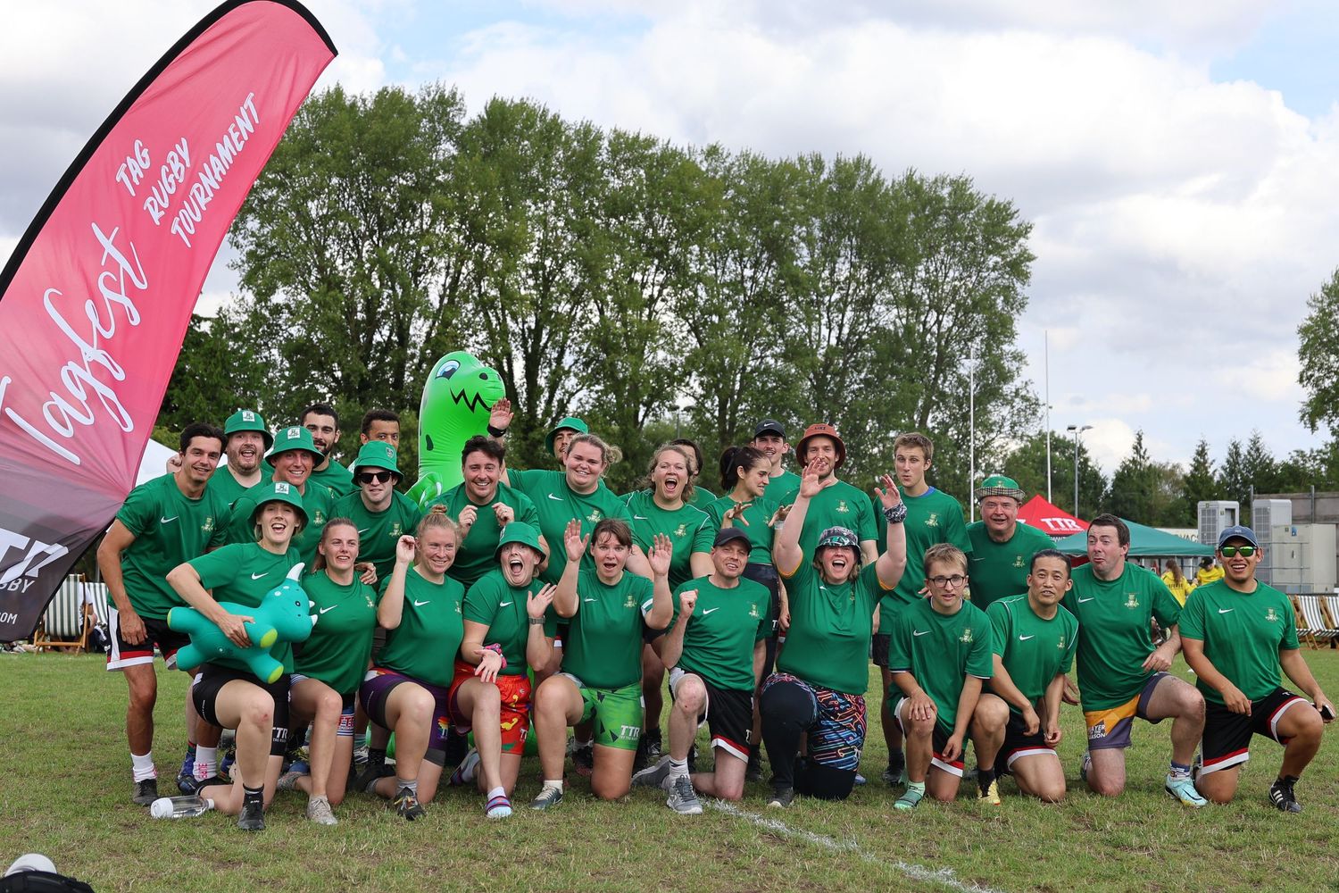 Tag Rugby team picture under the TTR tag flag with dinosaur blow up doll