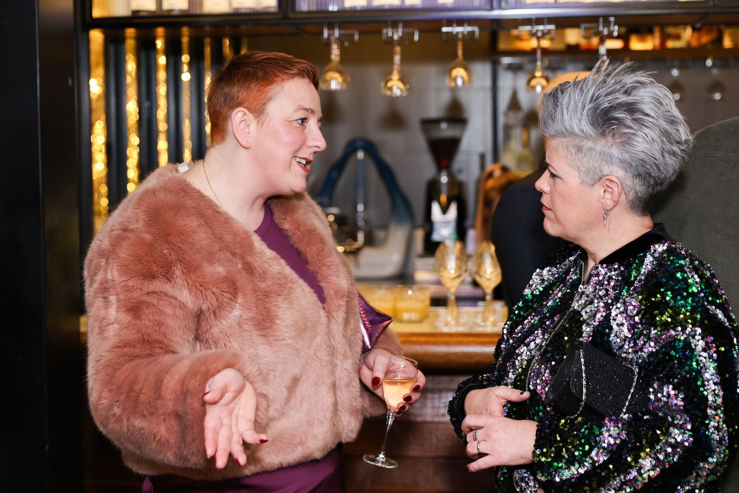 Two women at the event having a glass of wine each