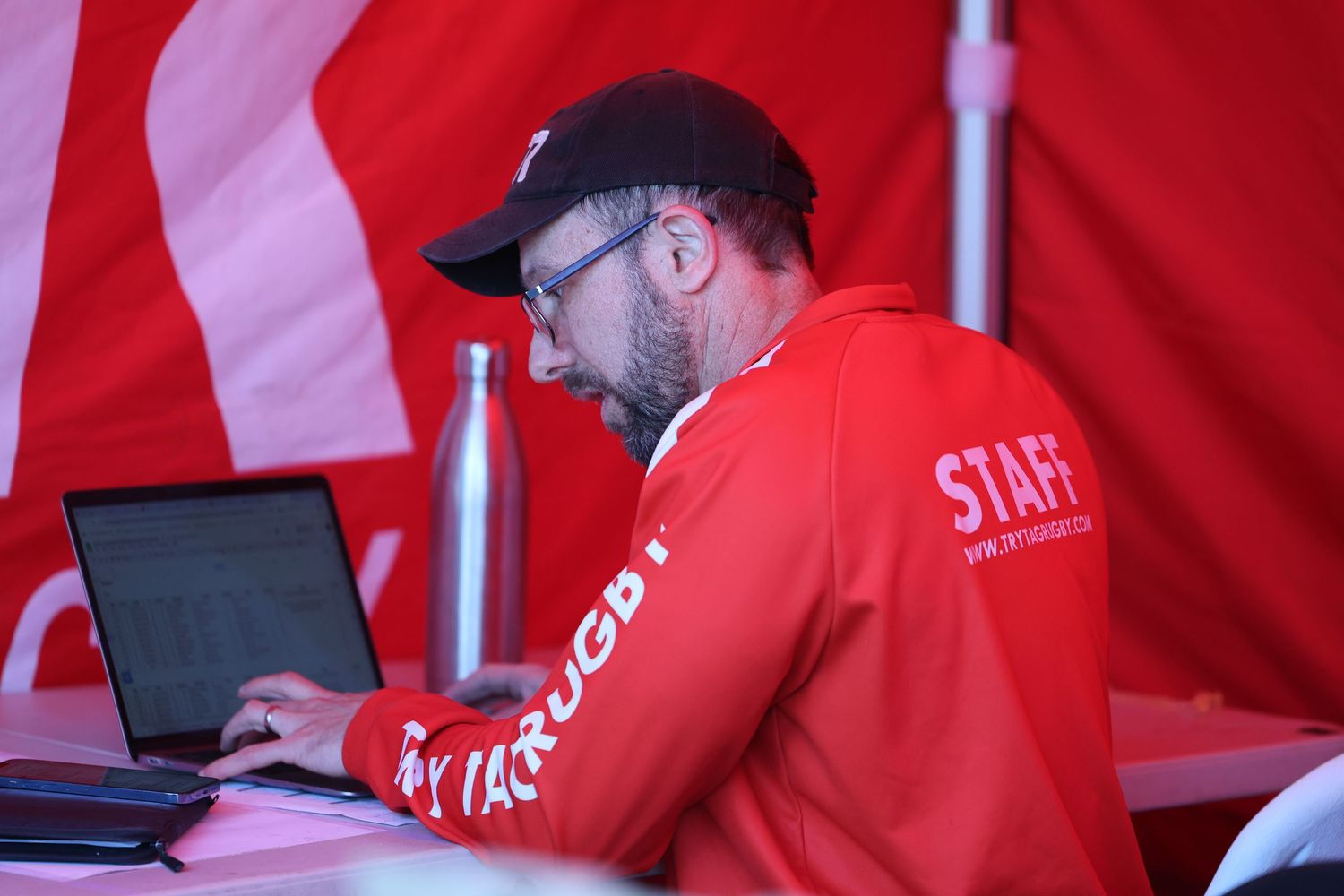 A man at a laptop working at an event