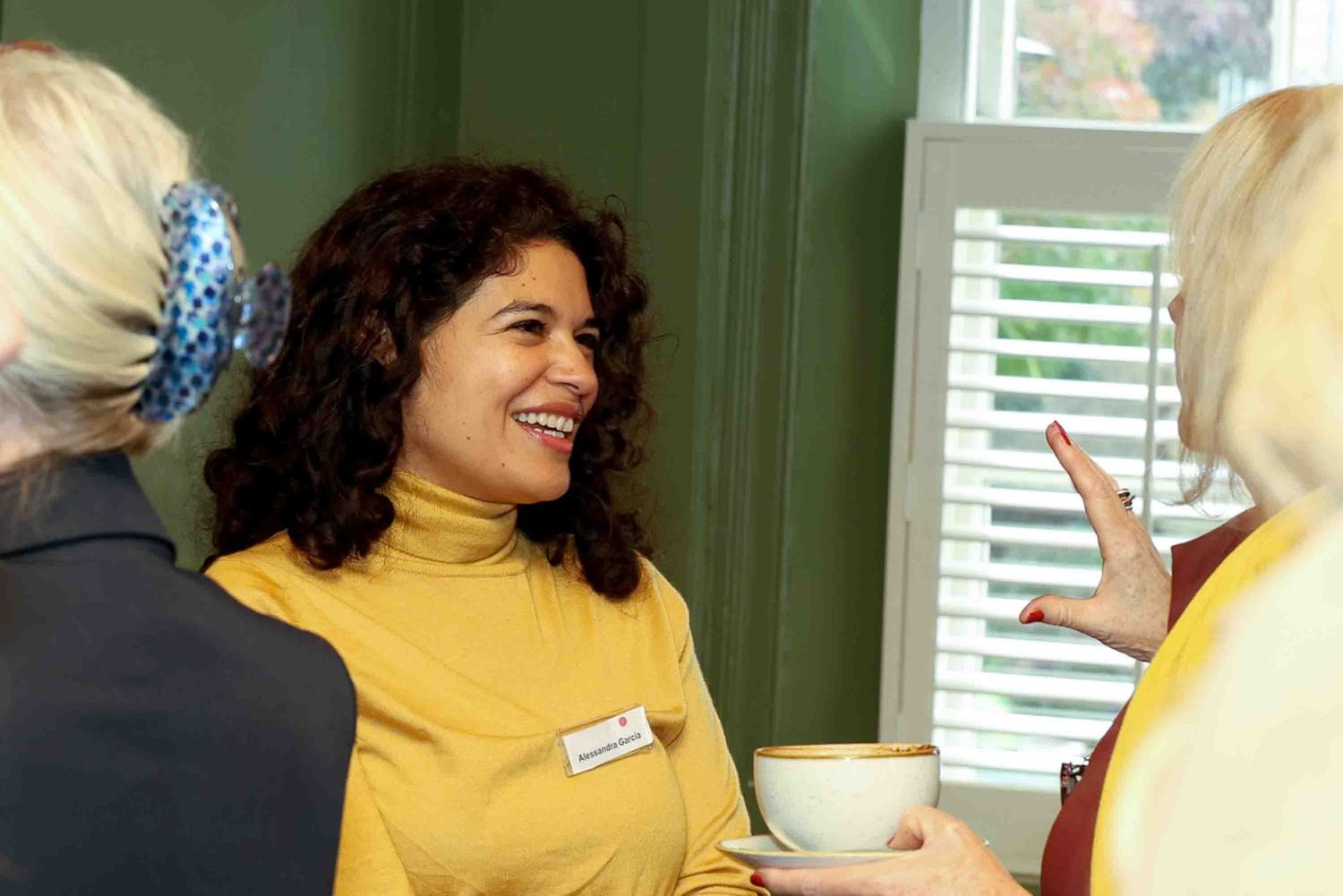 a woman in a yellow top talking to a group of women