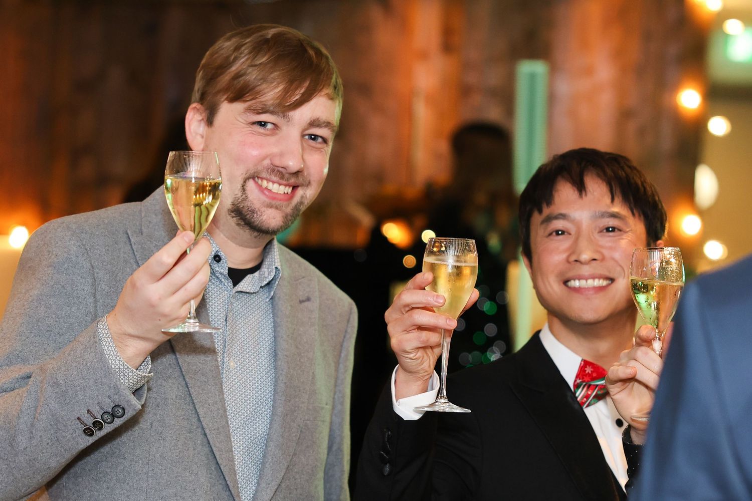 Two men cheersing the camera at an event
