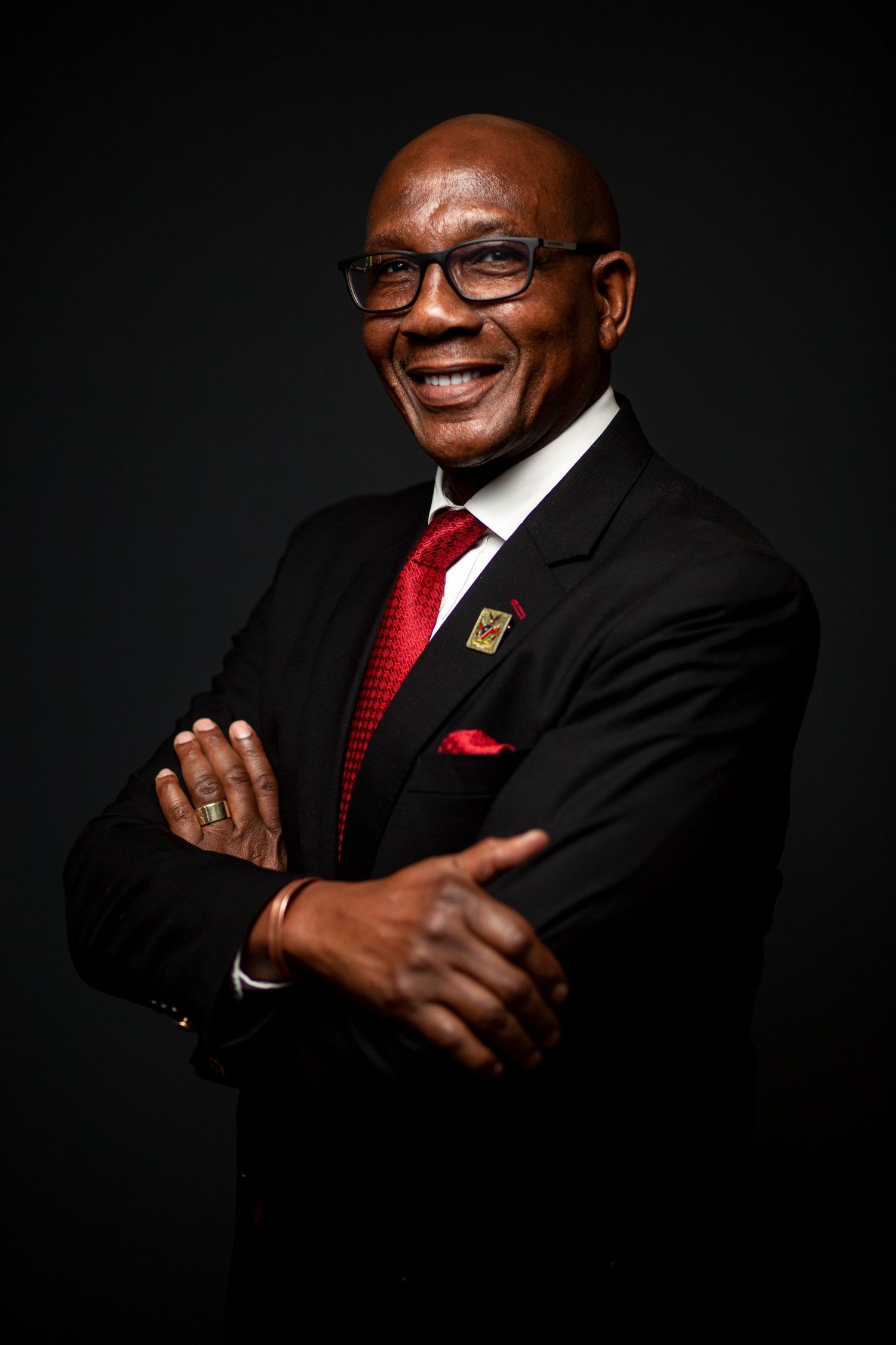 Dramatic portrait series featuring business professional in suit and red tie with glasses.