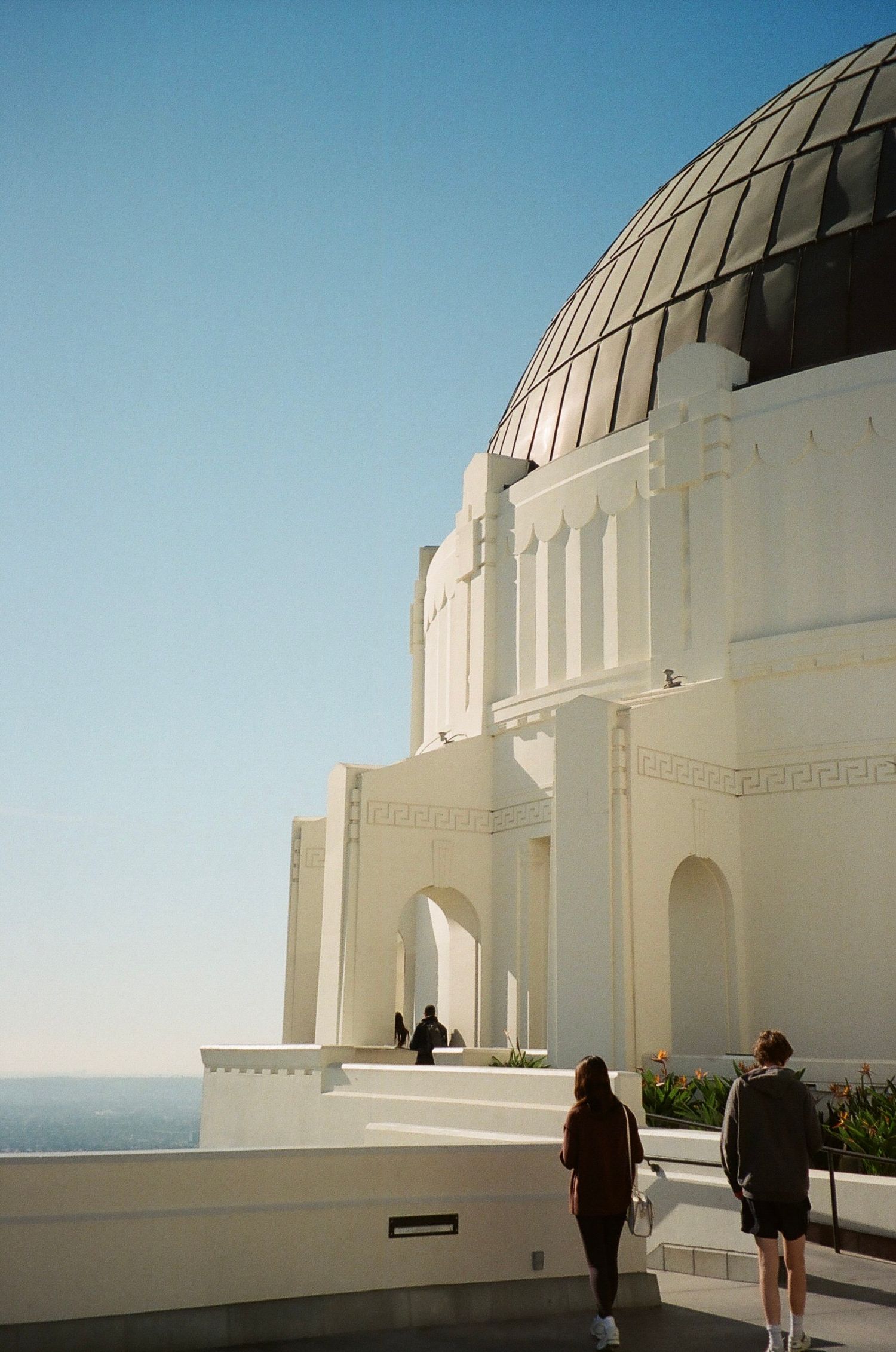 Film photograph of the iconic white domed Griffith Observatory in Los Angeles against a bright blue sky.