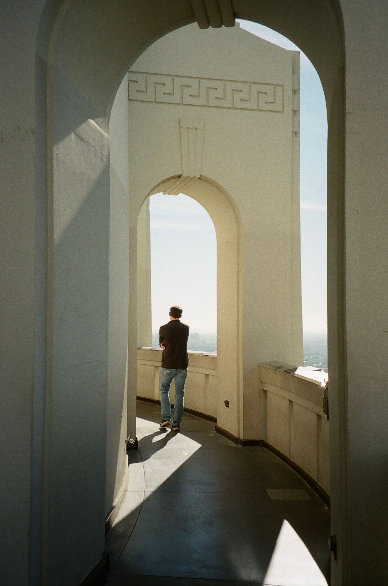 Film photograph of bright sunlight streams through arched doorways at the Griffith Observatory in Los Angeles, California.