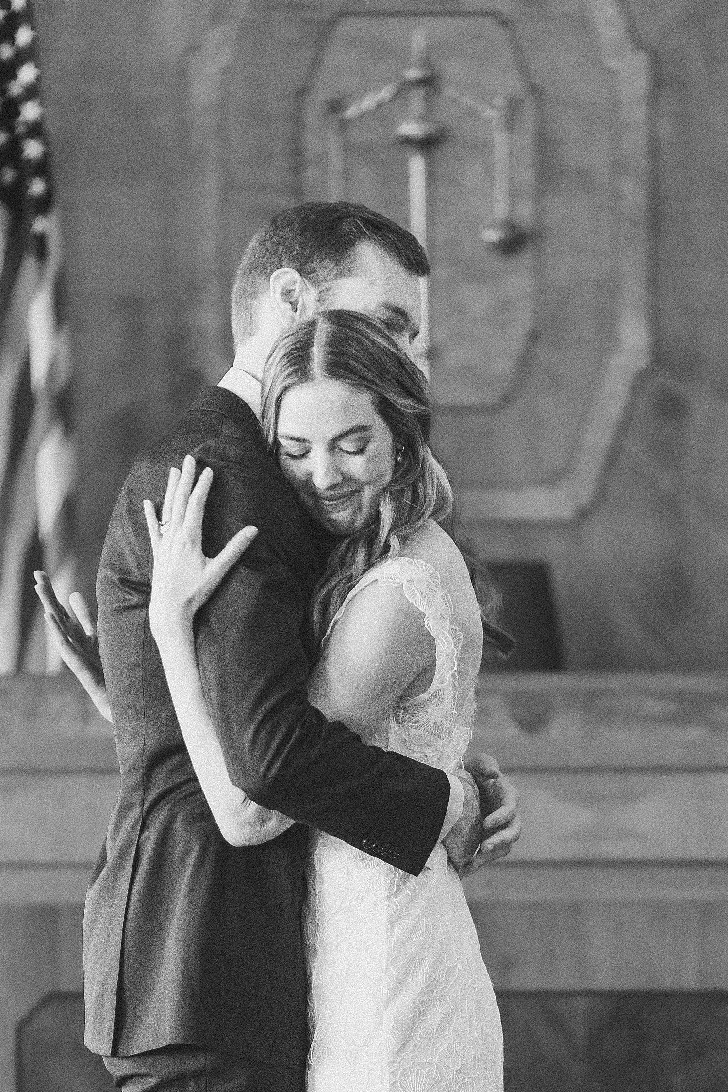 husband and wife embrace at the alter for a courthouse ceremony