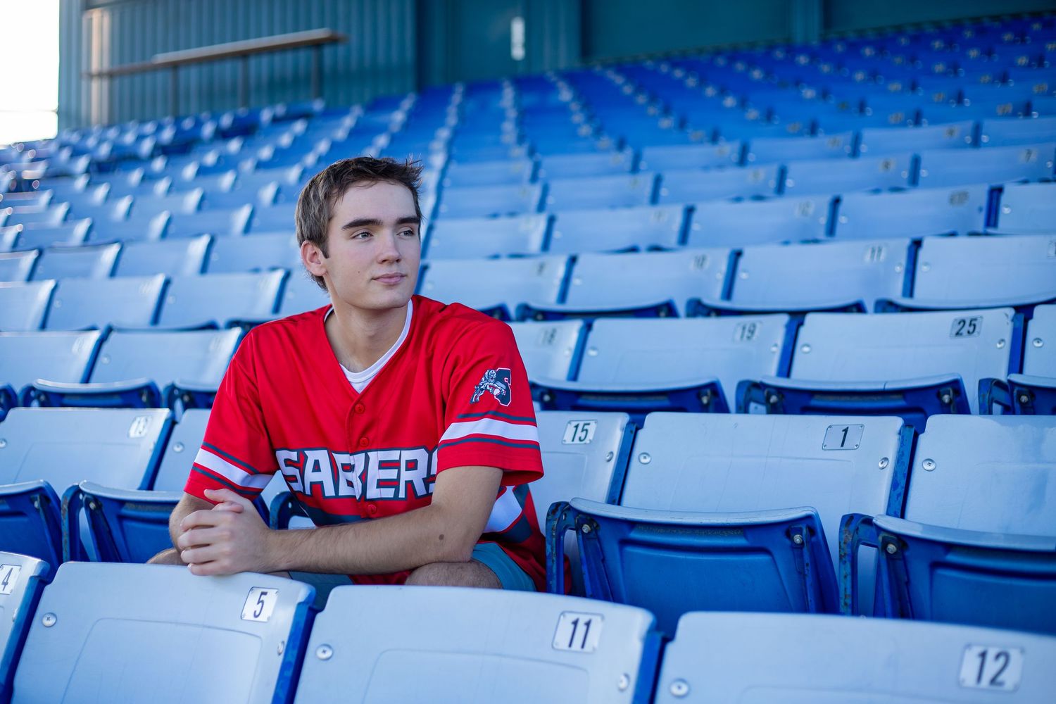 high-school-senior-photography-baseball-player-sitting-in-stadium-shakopee-mn.jpg