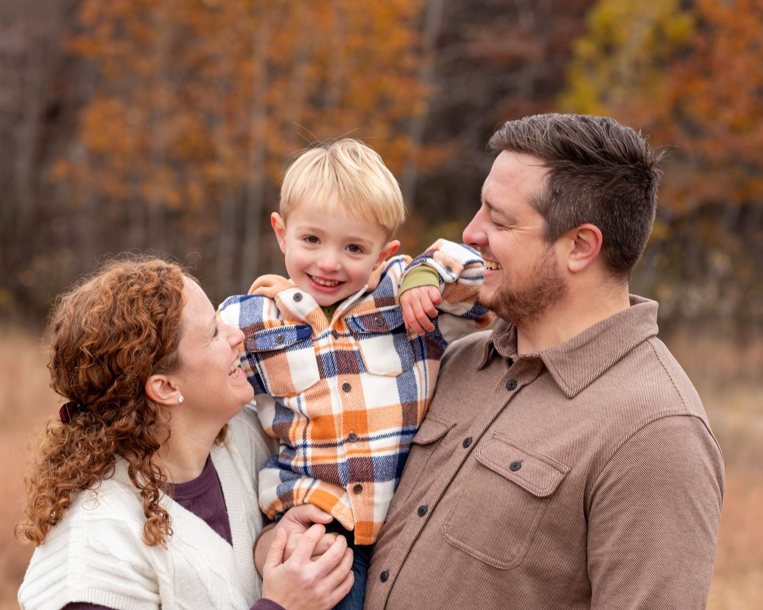 A series of candid family photos showing sweet moments between parent and child in an autumn setting with fall foliage.