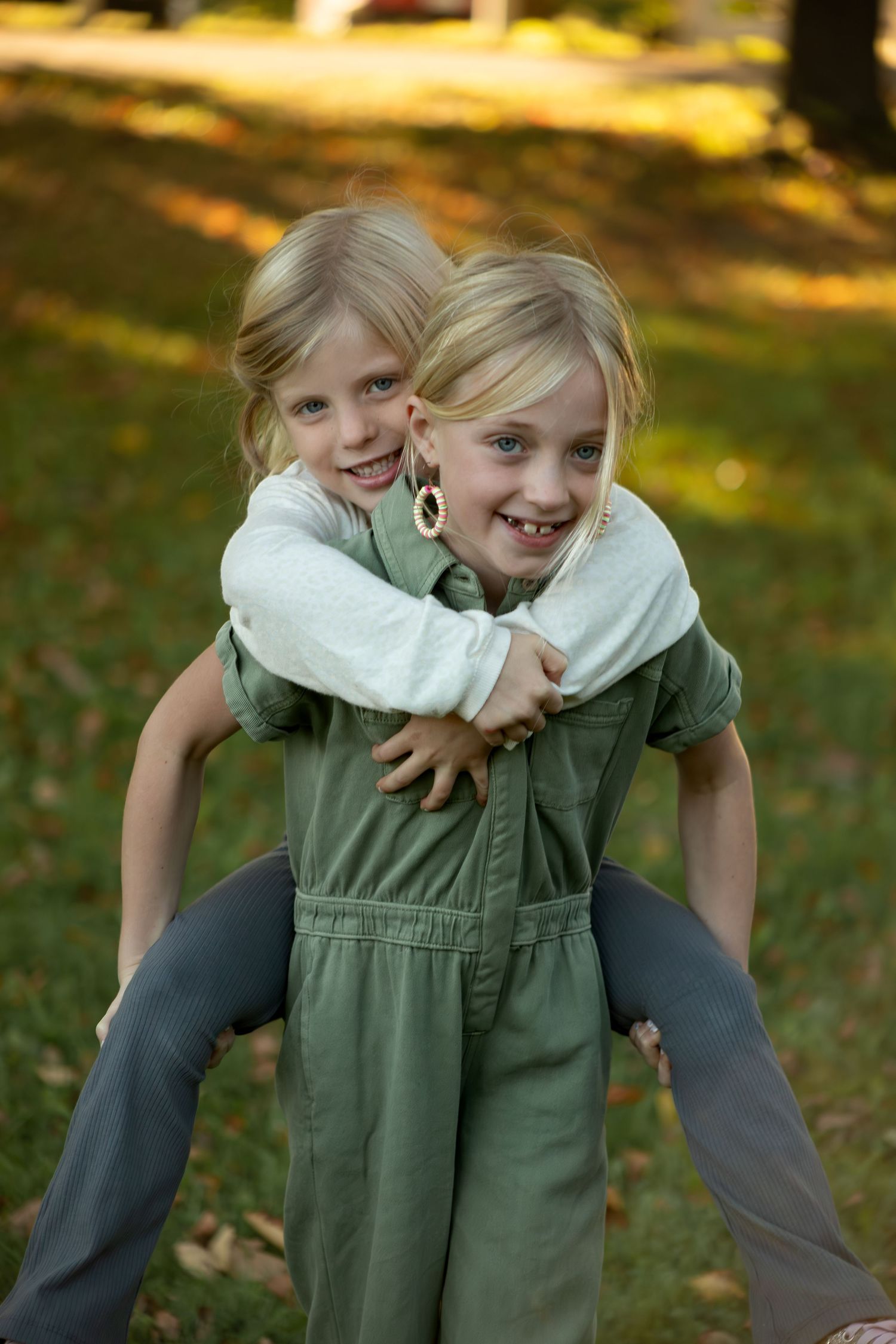 Playful piggyback rides and laughter during outdoor family photoshoot.