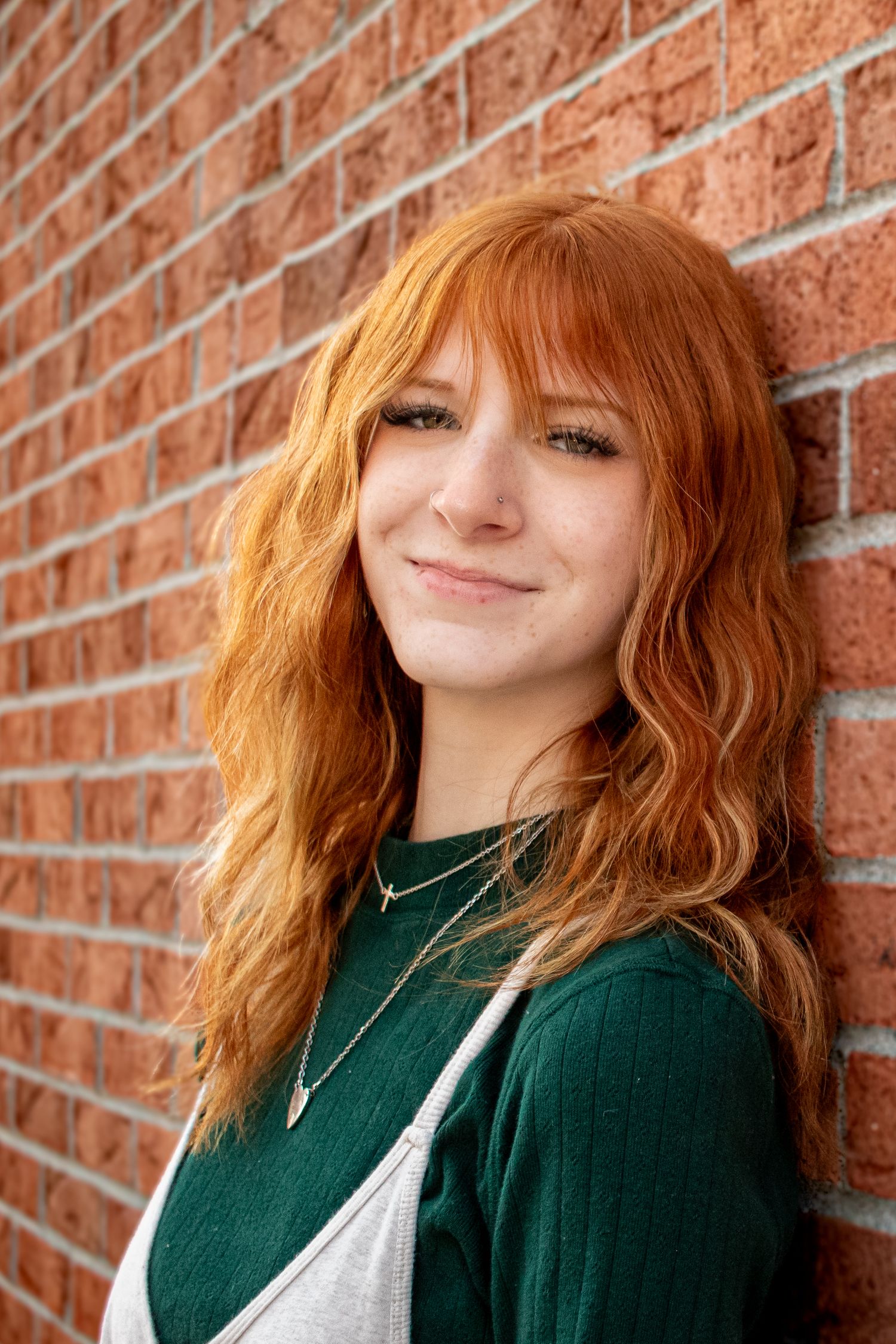senior photography, leaning against red brick background